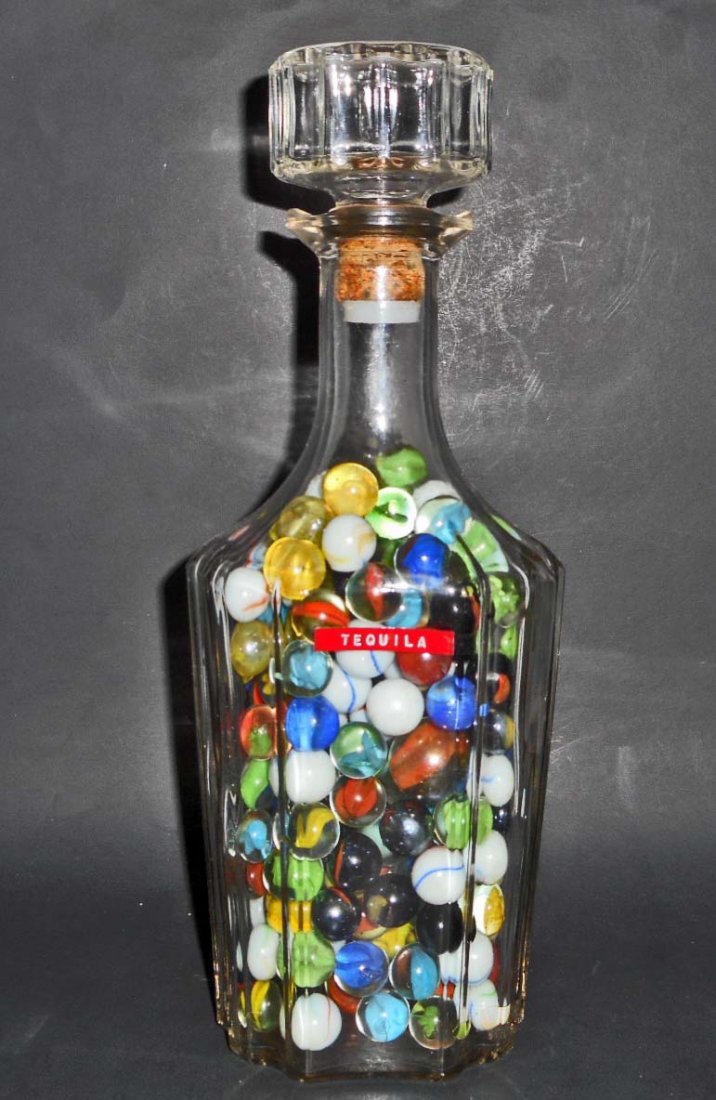 VINTAGE GLASS LIQUOR DECANTER FULL OF OLD MARBLES: N/A