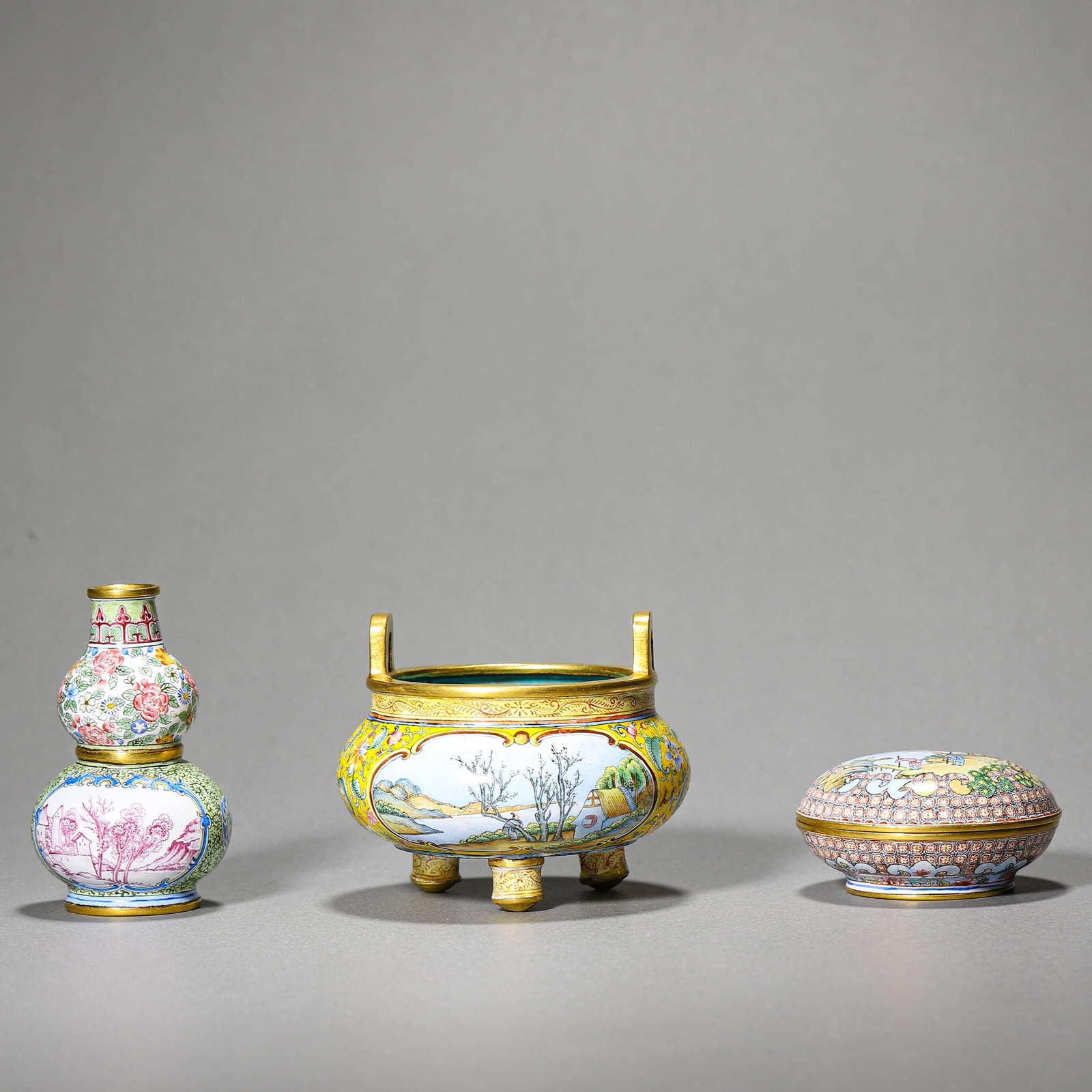 A PAINTED ENAMEL-ON-BRONZE THREE-PIECE GARNITURE SET: A PAINTED ENAMEL-ON-BRONZE THREE-PIECE GARNITURE SET Diameter: 2 3/4 in. (6.9 cm), Height: 2 3/8 in. (6 cm), Diameter: 2 in. (5 cm), Height: 1 1/8 in. (3 cm), Height: 2 5/8 in. (6.8 cm)