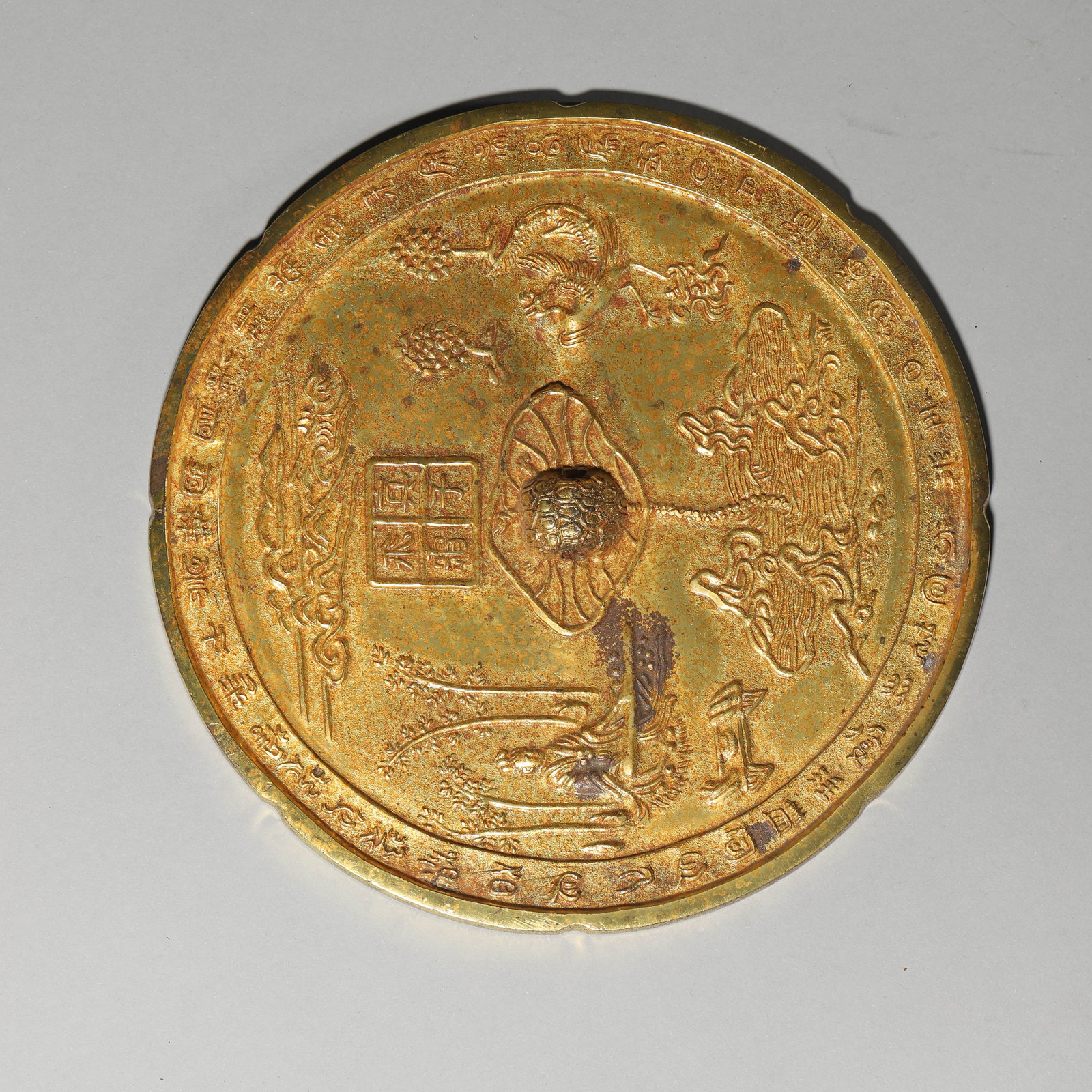 A GILT-BRONZE MIRROR: A GILT-BRONZE MIRROR Diameter: 7 7/8 in. (20 cm)