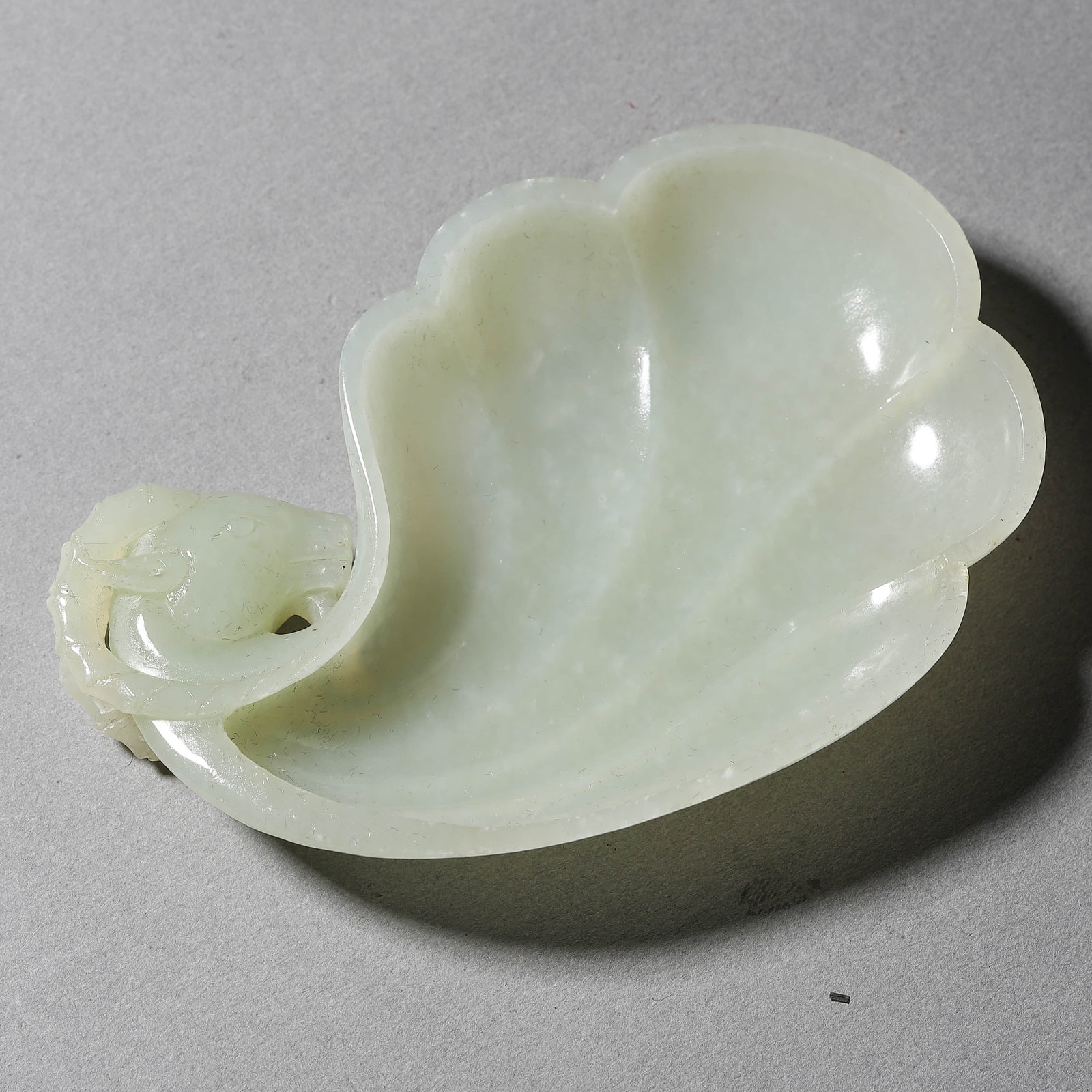 A QINGBAI JADE FLORAL-RIMMED WASHER: A QINGBAI JADE FLORAL-RIMMED WASHER Length: 4 3/16 in. (10.6 cm), Width: 2 7/8 in. (7.3 cm)