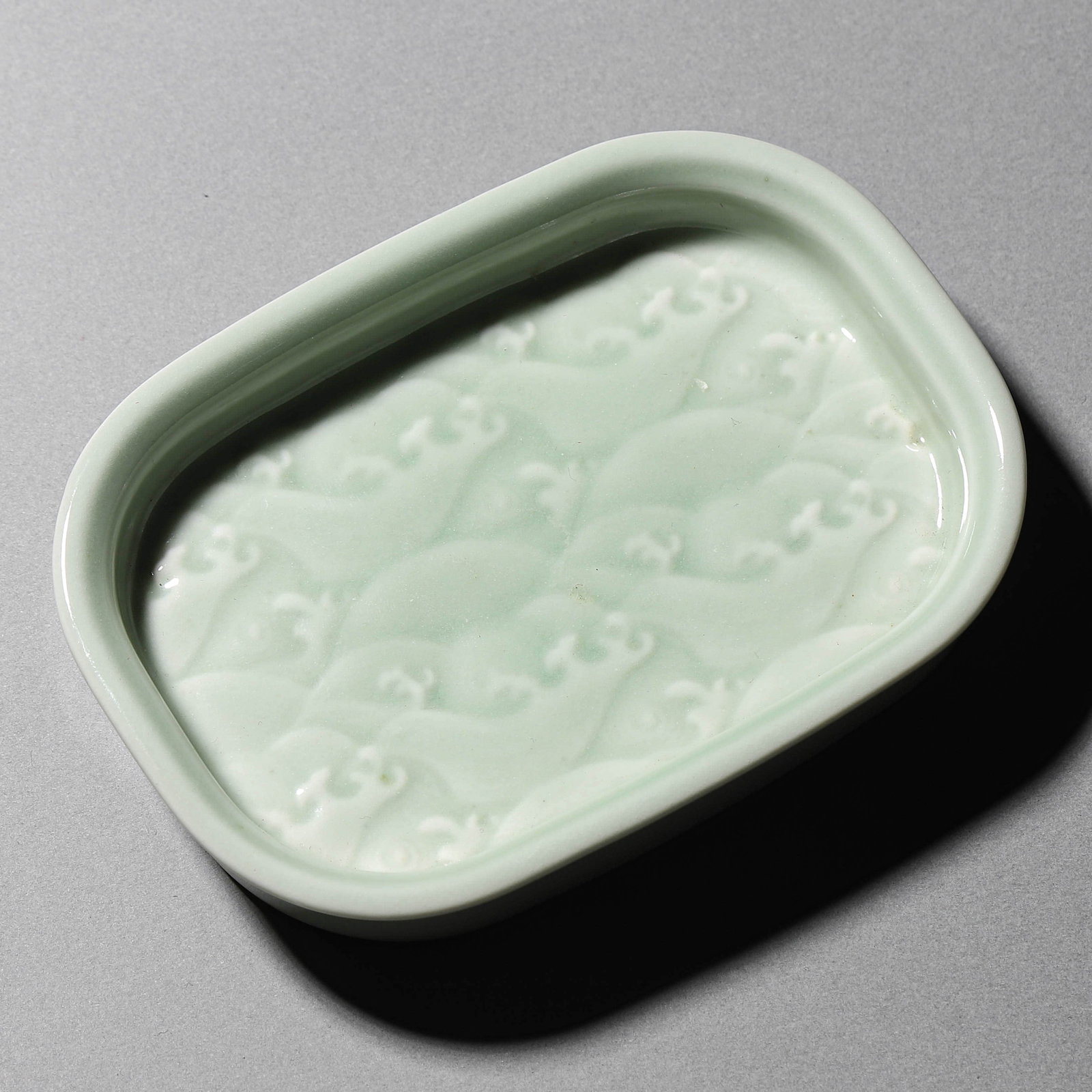 A CELADON GLAZED BRUSH REST: A CELADON GLAZED BRUSH REST Length: 4 1/2 in. (11.5 cm), Width: 3 1/4 in. (8.3 cm), Height: 13/16 in. (2 cm)