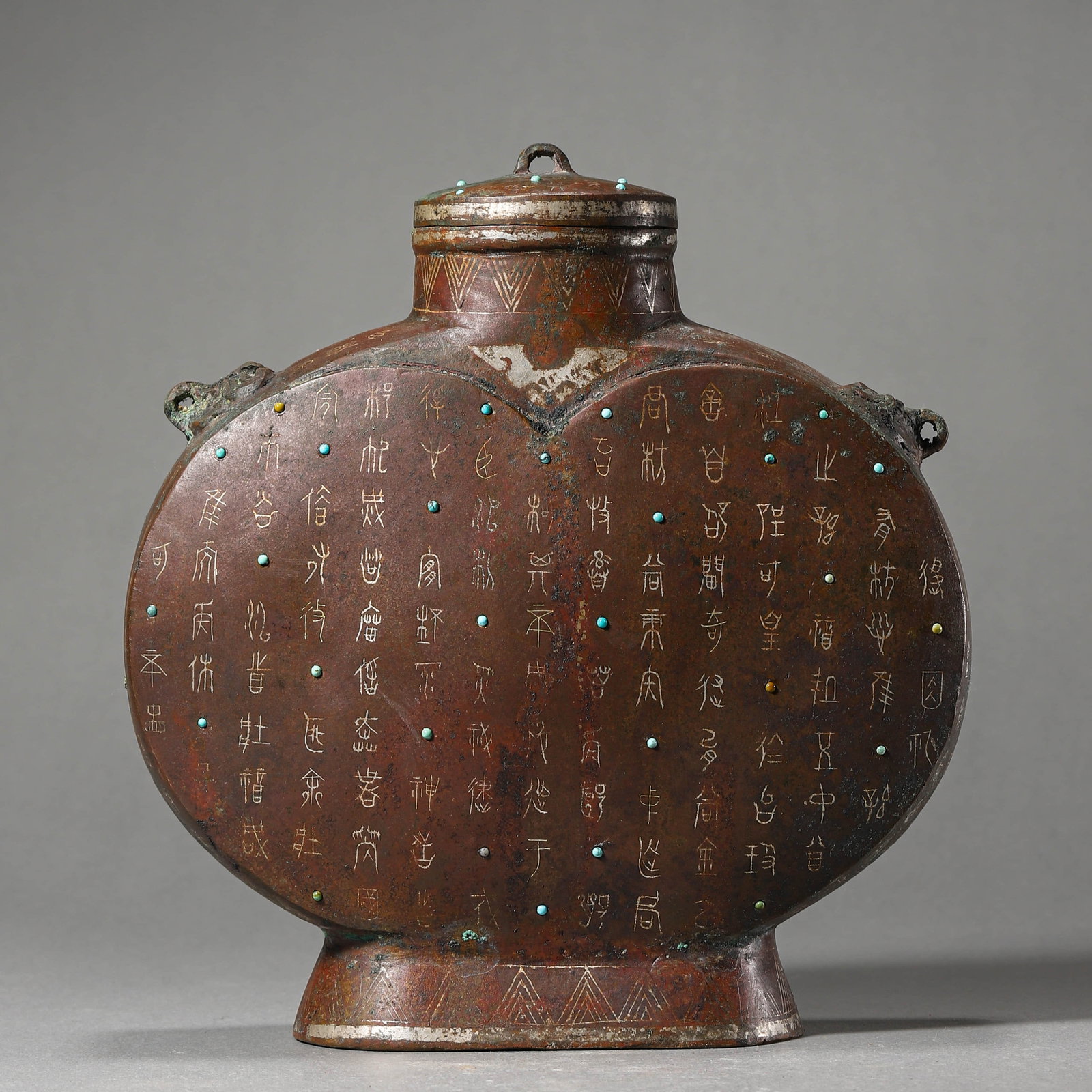A GOLD AND SILVER-INLAID FLATTENED VESSEL: A GOLD AND SILVER-INLAID FLATTENED VESSEL Length: 7 1/16 in. (19 cm), Width: 7 1/2 in. (18 cm)
