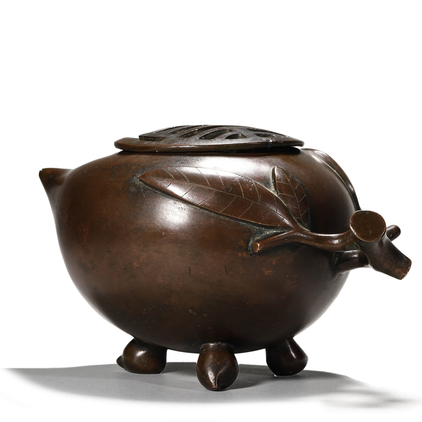 A BRONZE PEACH-SHAPED CENSER: A BRONZE PEACH-SHAPED CENSER Length: 8 7/16 in. (21.5 cm), Height: 5 1/8 in. (13 cm)