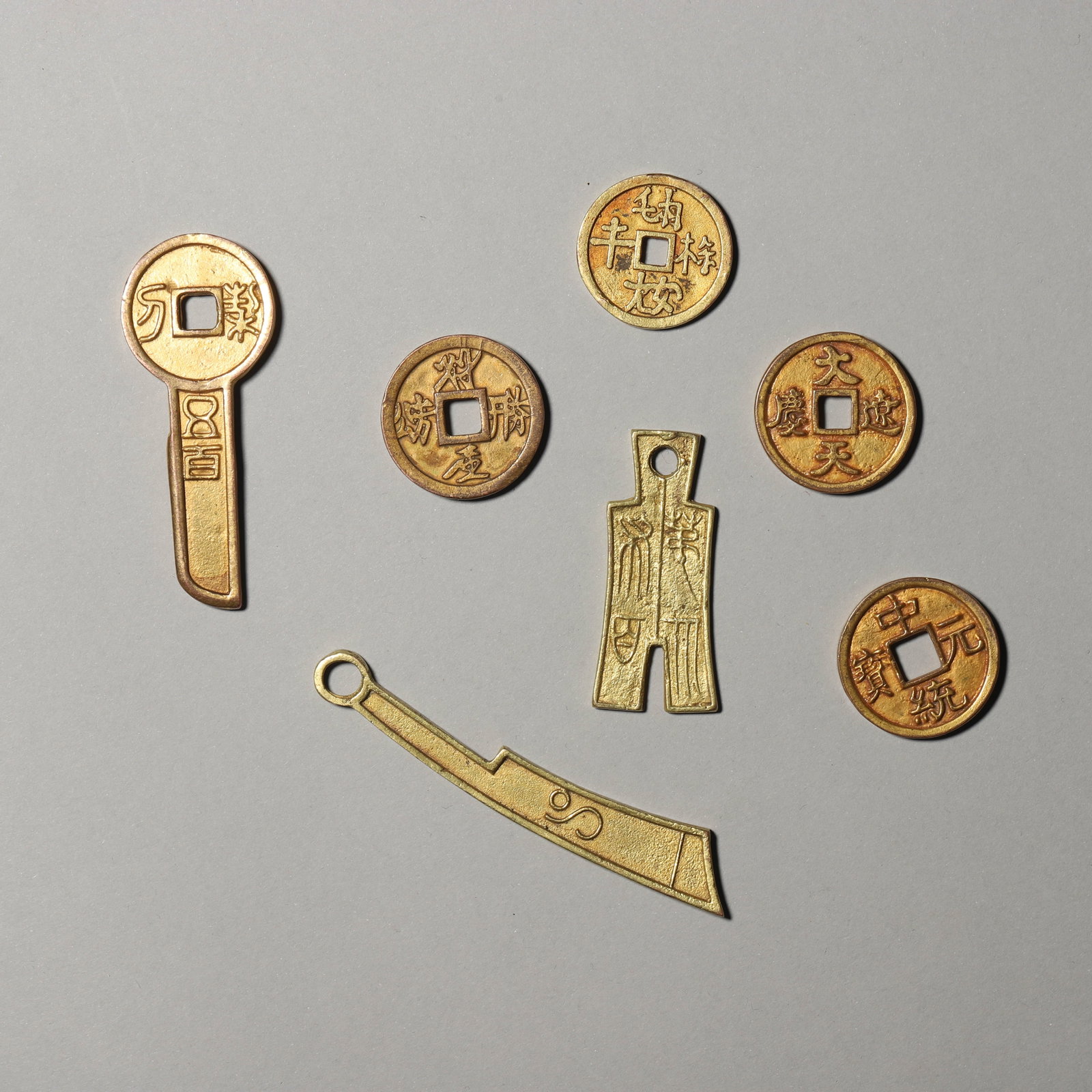 A GROUP OF GILT-BRONZE COINS: A GROUP OF GILT-BRONZE COINS Length: 3 1/8 in. (8 cm)
