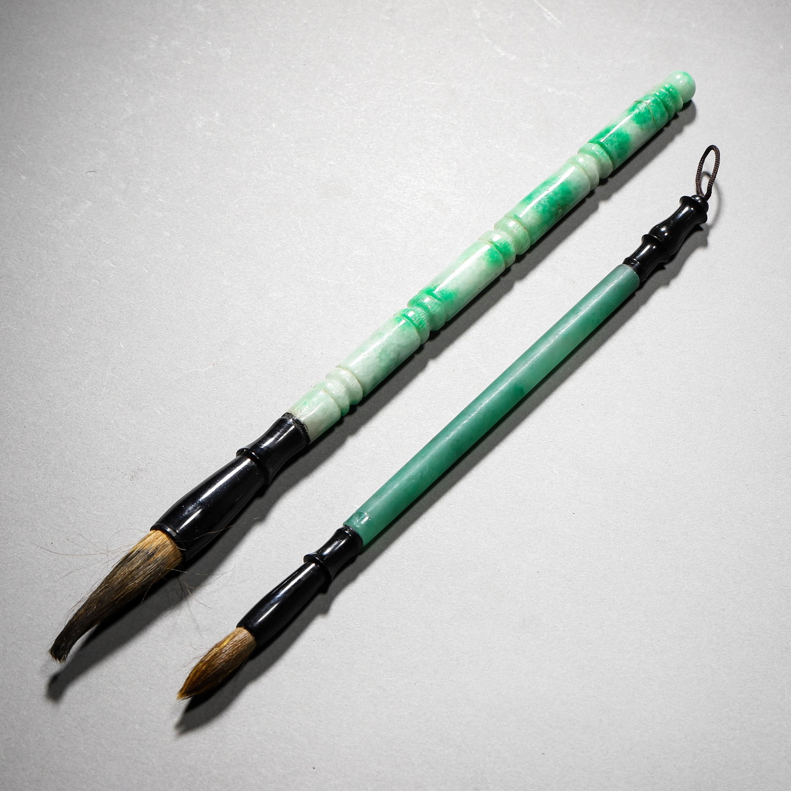 A SET OF JADEITE AND DUSHAN JADE BRUSHES: A SET OF JADEITE AND DUSHAN JADE BRUSHES Length: 9 1/4 in. (23.5 cm), Length: 11 1/4 in. (28.5 cm)