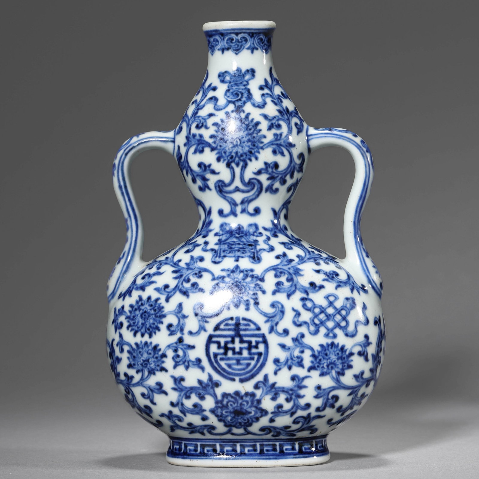 A BLUE AND WHITE 'FLOWERS AND RIBBON' DOUBLE-GOURD VASE: A BLUE AND WHITE 'FLOWERS AND RIBBON' DOUBLE-GOURD VASE Height: 6 7/8 in. (17.5 cm)