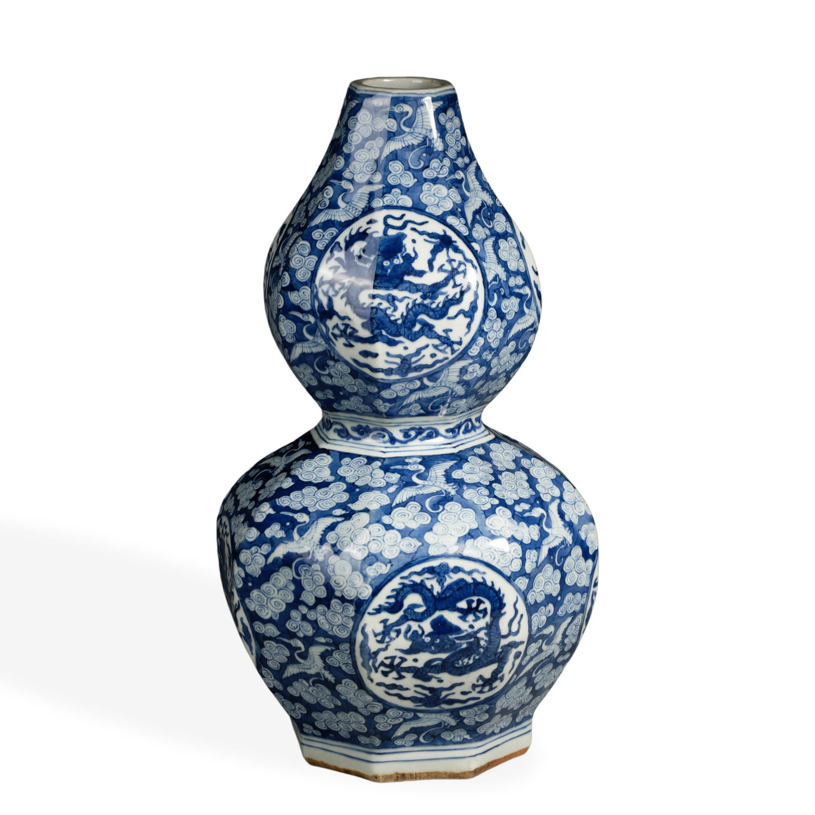 MING JIAJING BLUE AND WHITE HEXAGONAL GOURD-SHAPED VASE WITH CRANES, AUSPICIOUS CLOUDS, AND: 13 5/8 x 5 1/2 in (34.5 x 14 cm) Ming Jiajing Blue and White Hexagonal Gourd-Shaped Vase with Cranes, Auspicious Clouds, and Medallion Dragons Dimensions: H: 13 5/8 in (34.5 cm); W: 5 1/2 in (14 cm)