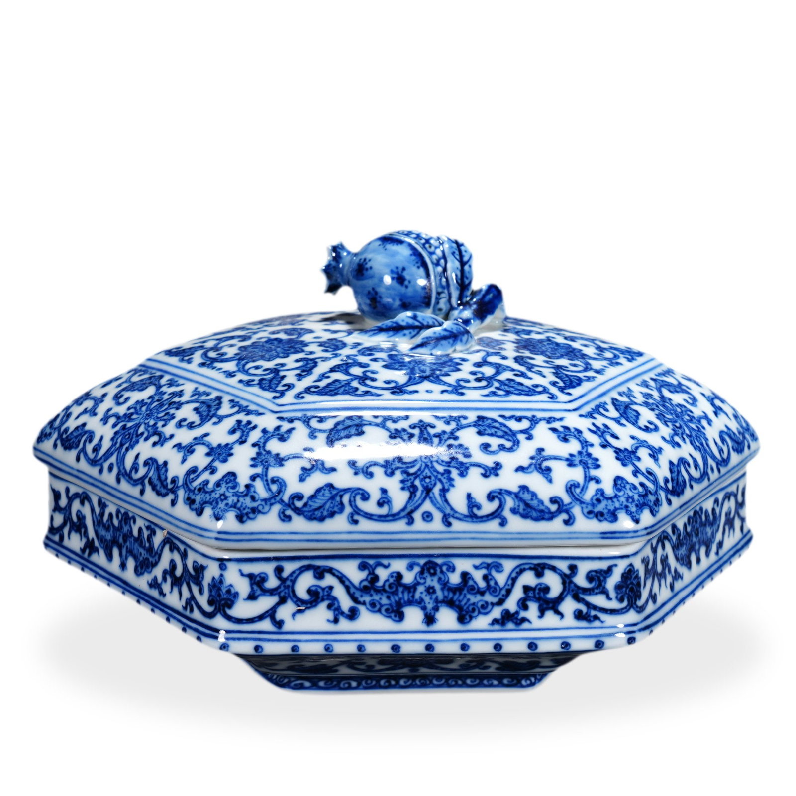 QIANLONG BLUE AND WHITE 'LOTUS SCROLL' HEXAGONAL COVERED BOX: 5 1/8 x 9 7/8 in (13 x 25 cm) Qianlong Blue and White 'Lotus Scroll' Hexagonal Covered Box Dimensions: H: 5 1/8 in (13 cm); W: 9 7/8 in (25 cm) This impressive hexagonal covered box exemplifies the