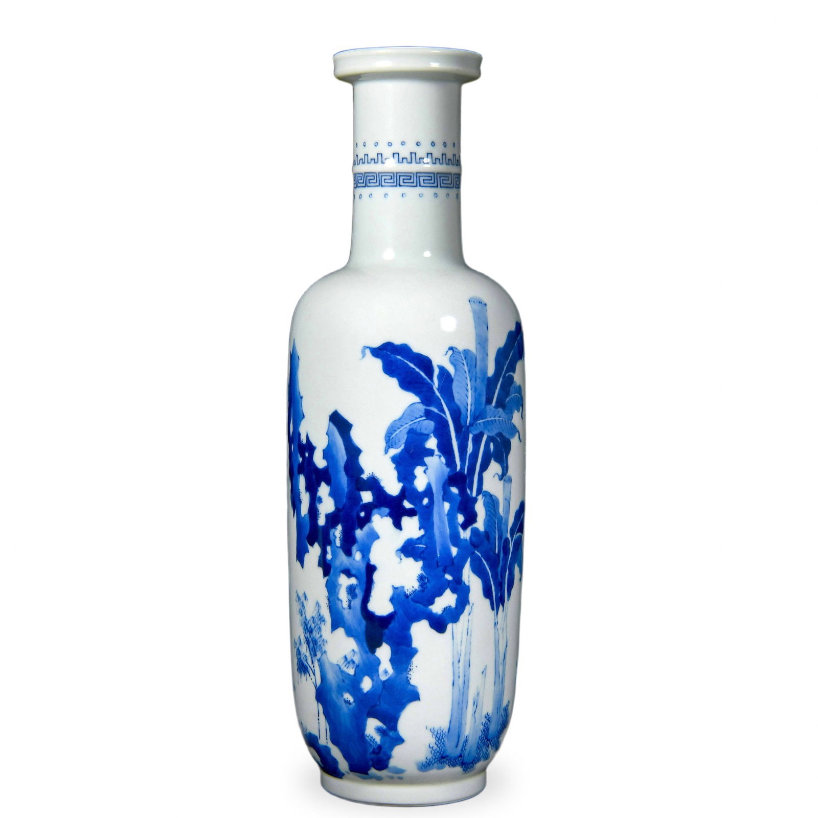 KANGXI BLUE AND WHITE 'BANANA PLANTS AND GARDEN ROCKS' ROULEAU VASE: Kangxi Blue and White 'Banana Plants and Garden Rocks' Rouleau Vase Dimensions: H: 12 5/8 in (32 cm); W: 3 1/2 in (9 cm) This stately rouleau (bangchui ping or 'mallet') vase is among the most iconic