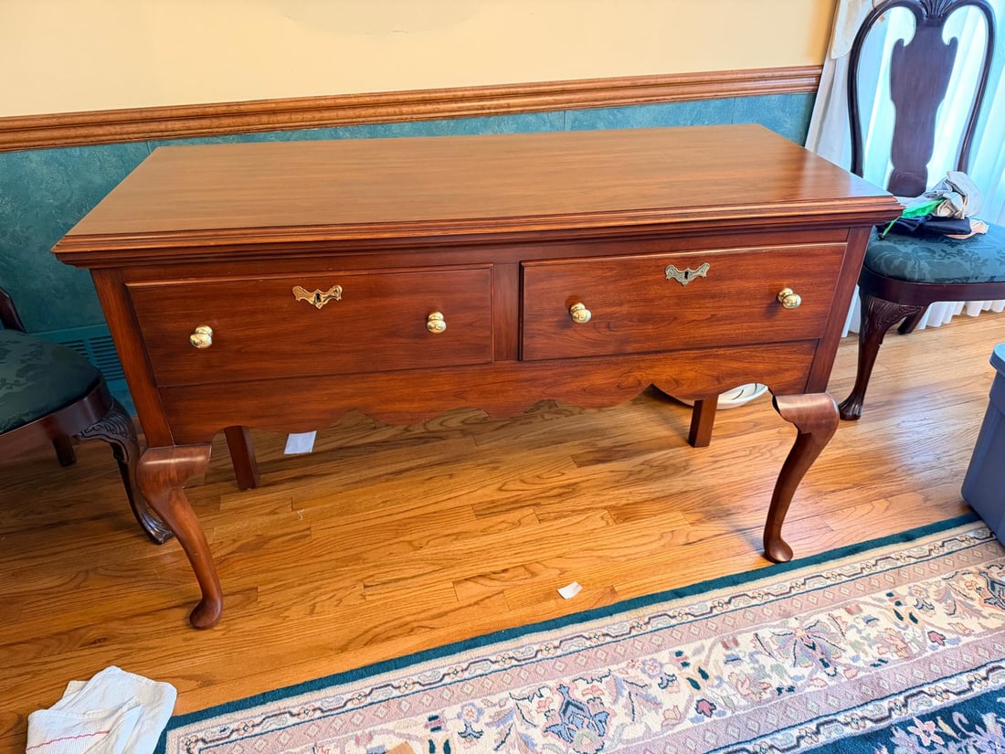 Vintage Queen Anne Style Two Drawer Sideboard: Queen Anne style sideboard, 53"W x 21"D x 34"H, two drawers, cabriole legs, brass hardware, and warm wood finish.A vintage Queen Anne style sideboard featuring a rectangular top, two spacious drawers,