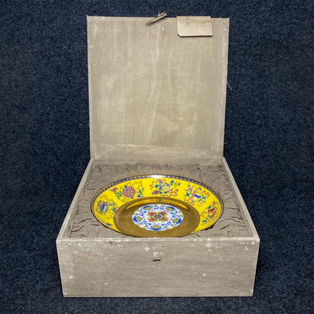 A large famille rose and gilt-bronze auspicious eight treasures plate from the Palace Museum: The Palace Museum collection features a famille rose and gilt-bronze auspicious eight treasures plate. The plate's dimensions are: diameter 20.3cm, height 3.7cm. The box's dimensions are: length x wid