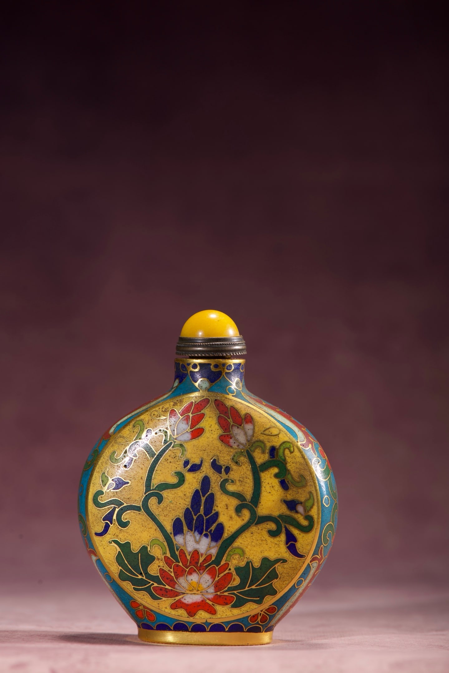 Copper-bodied cloisonne enamel snuff bottle with floral pattern: A copper-bodied cloisonne enamel snuff bottle with floral design, 77mm high, 62mm wide, 29mm thick, weighing 80g. Thank you for viewing our auction and we look forward to serving you as a valued