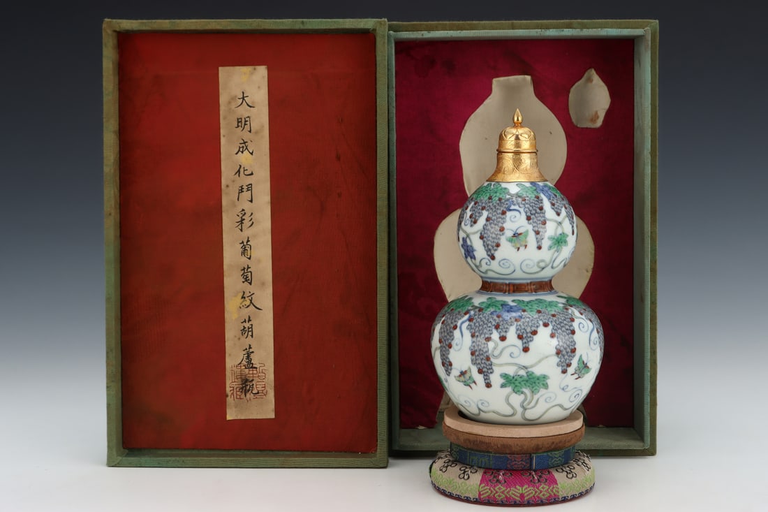 A Ming Dynasty Chenghua period doucai gourd-shaped vase with gold-plated and engraved grape design,: A Ming Dynasty Chenghua period doucai (enamel overglaze enamel) gourd-shaped vase with gold-plated and engraved grape design, formerly in the collection. Dimensions: Height: 18.3cm, Diameter: 10cm. Th