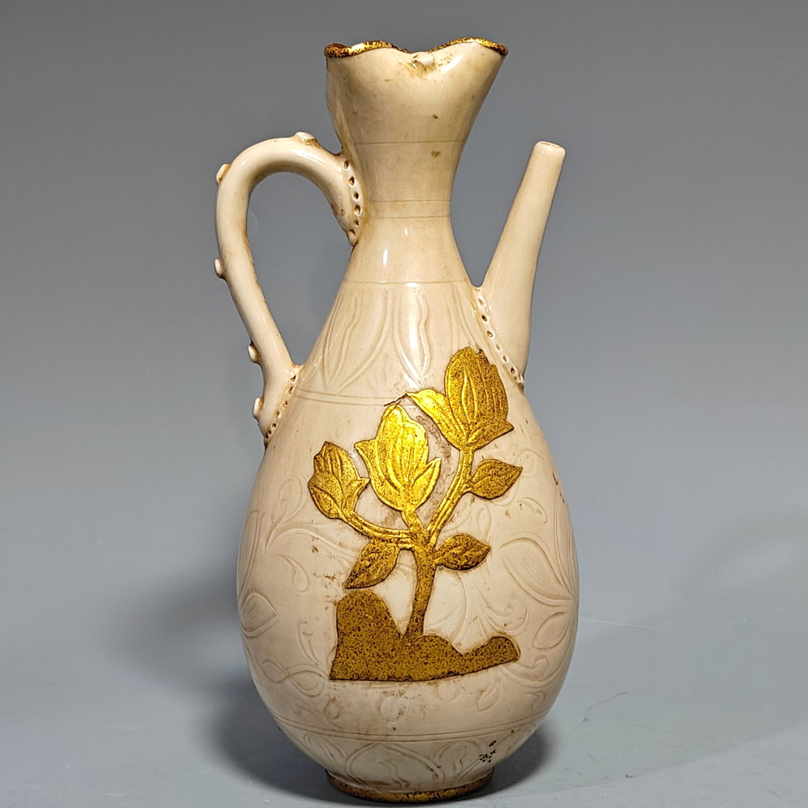 Song Dynasty Ding Porcelain Teapot with Engraved Poems and Gold Inlay: This Song Dynasty Ding ware ewer, inlaid with gold and decorated with engraved poems, is a collectible piece. It boasts a beautiful and elegant design, is handcrafted with exquisite workmanship, and f