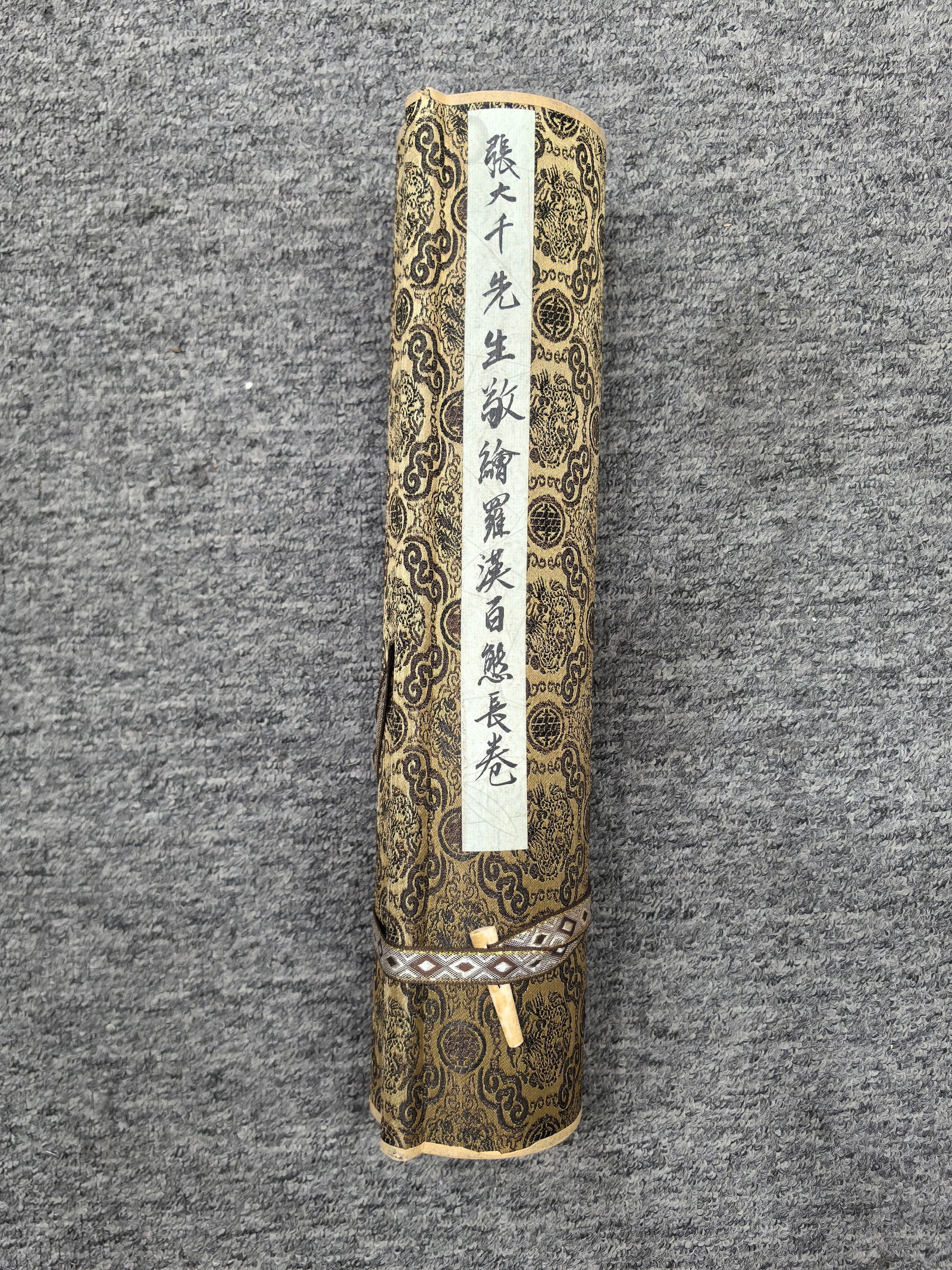 Zhang Daqian's exquisite long scroll of paper depicting various Arhats.: Zhang Daqian's exquisite paper scroll depicting one hundred Arhats, approximately 34.7 cm x 10 meters in total length and width, with the painting itself measuring approximately 34.1 cm x 7.5 meters. 