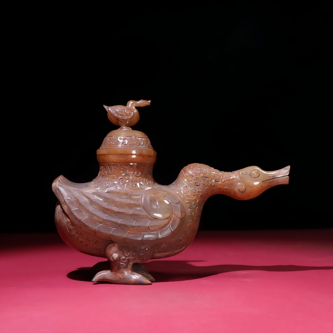 Exquisite antique collection, white jade duck vase with earthy, yellow, and slightly red patina.: A fine, historically significant piece: a white jade duck-shaped vase with a rich, deep patina, infused with yellow and red hues. The craftsmanship is exquisite, the carving sharp and precise. A rare 