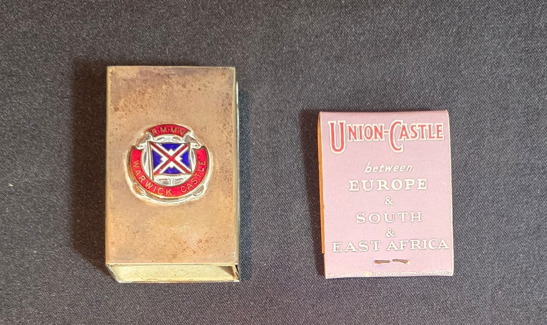 Union Castle Line Silver Matchbox Holder and Matchbook: R.M.M.V. Warwick Castle Matchbox holder with box (no matches) and Union Castle Line Matchbook. 50% of all proceeds from the sale of this lot will be donated to the Raise Your Banner Foundation, a