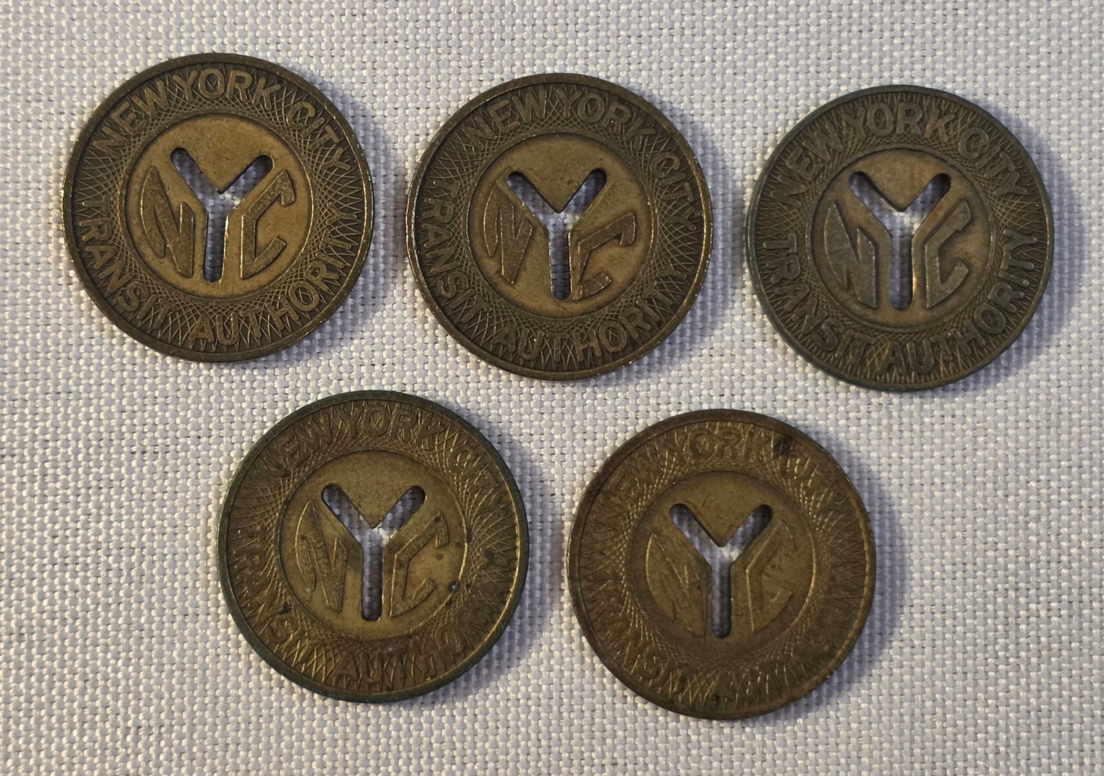 New York City Transit Token Lot: 5x 23mm, 1970-80. 50% of all proceeds from the sale of this lot will be donated to the Raise Your Banner Foundation, a Washington DC based non-profit whose mission is to break down the stigma