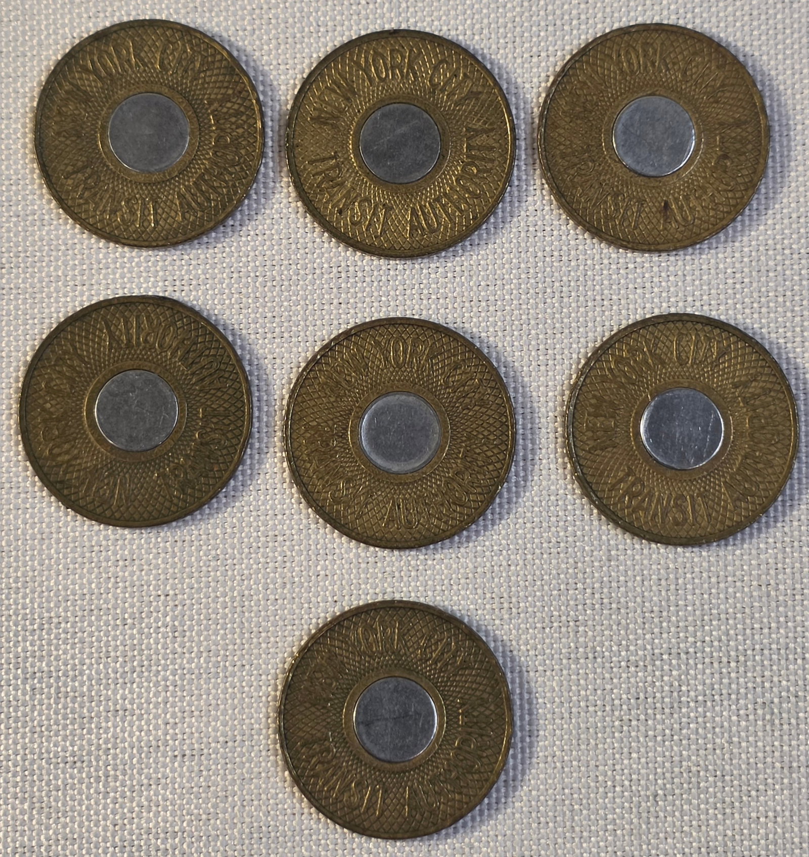 New York City Transit Token Lot: 7x 22mm, 1986-89. 50% of all proceeds from the sale of this lot will be donated to the Raise Your Banner Foundation, a Washington DC based non-profit whose mission is to break down the stigma