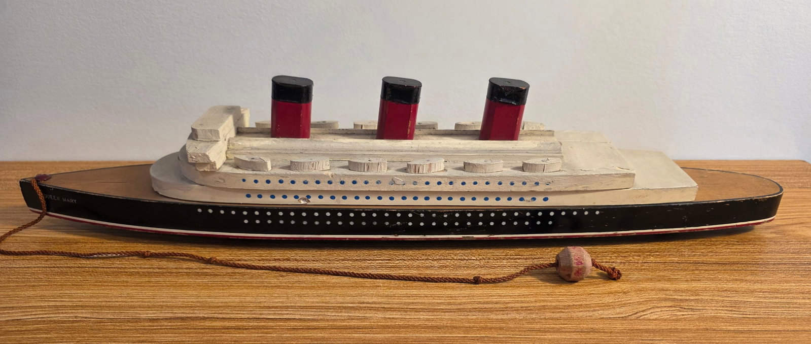 Cunard R.M.S. Queen Mary Wood Pull Toy: Unmarked, 20" long. 50% of all proceeds from the sale of this lot will be donated to the Raise Your Banner Foundation, a Washington DC based non-profit whose mission is to break down the stigma