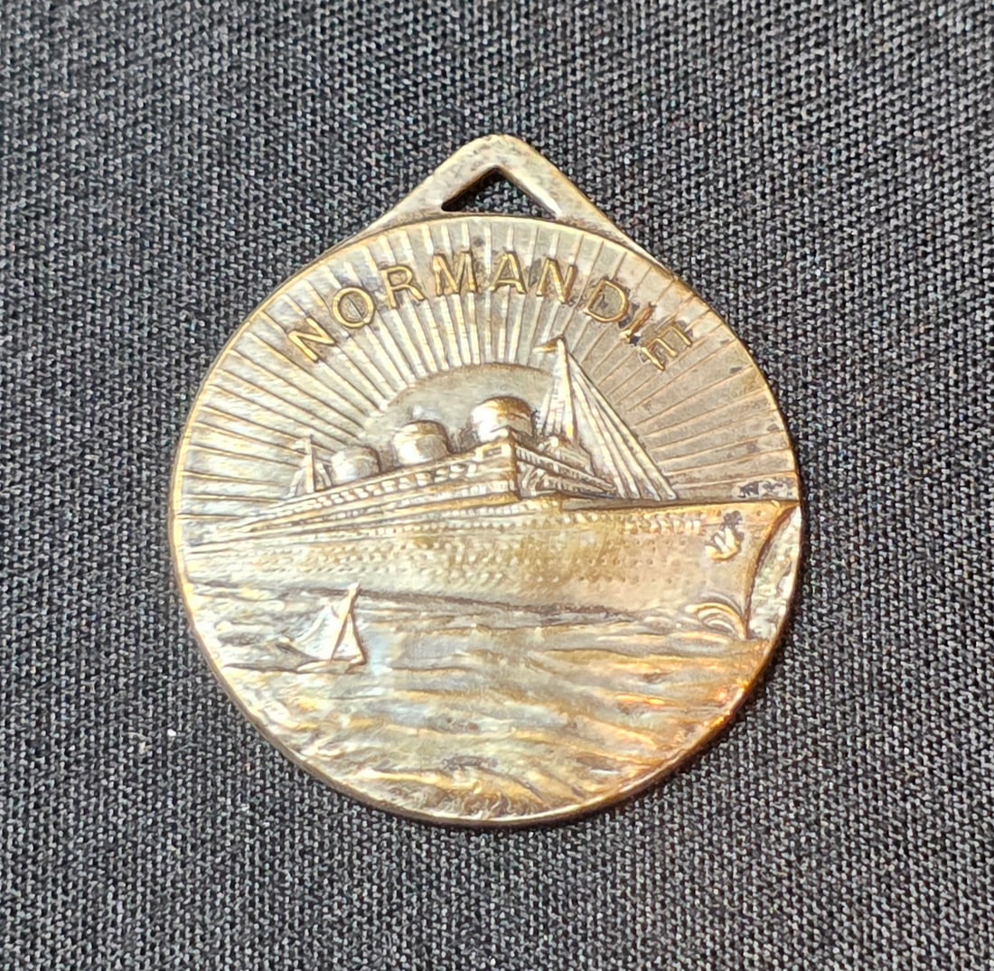 French Line S.S. Normandie Pendant: Small 1" Pendant. Undated. 50% of all proceeds from the sale of this lot will be donated to the Raise Your Banner Foundation, a Washington DC based non-profit whose mission is to break down the