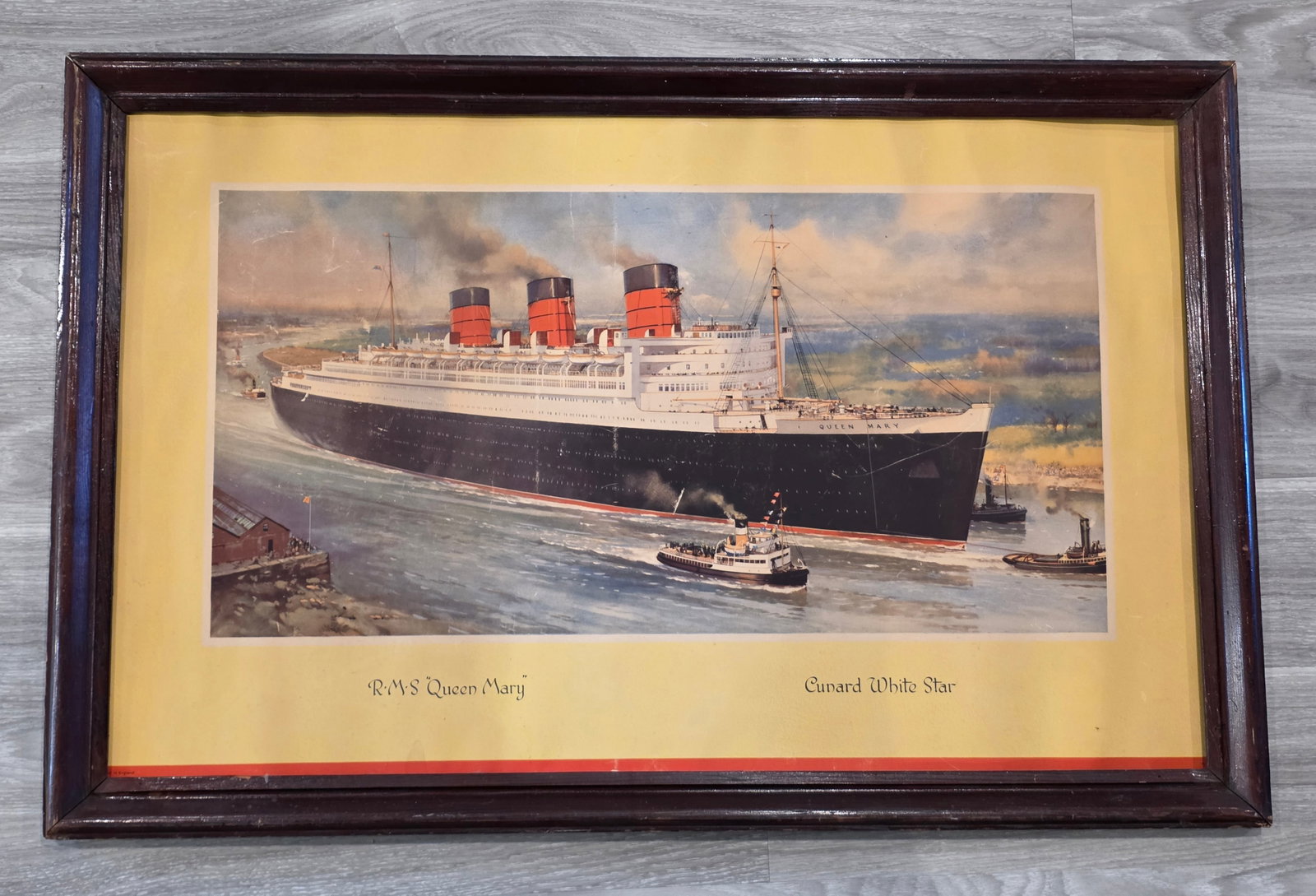 Cunard R.M.S. Queen Mary Framed Travel Agency Art: Color print, no glass. Measures 37" x 24". 50% of all proceeds from the sale of this lot will be donated to the Raise Your Banner Foundation, a Washington DC based non-profit whose mission is to break