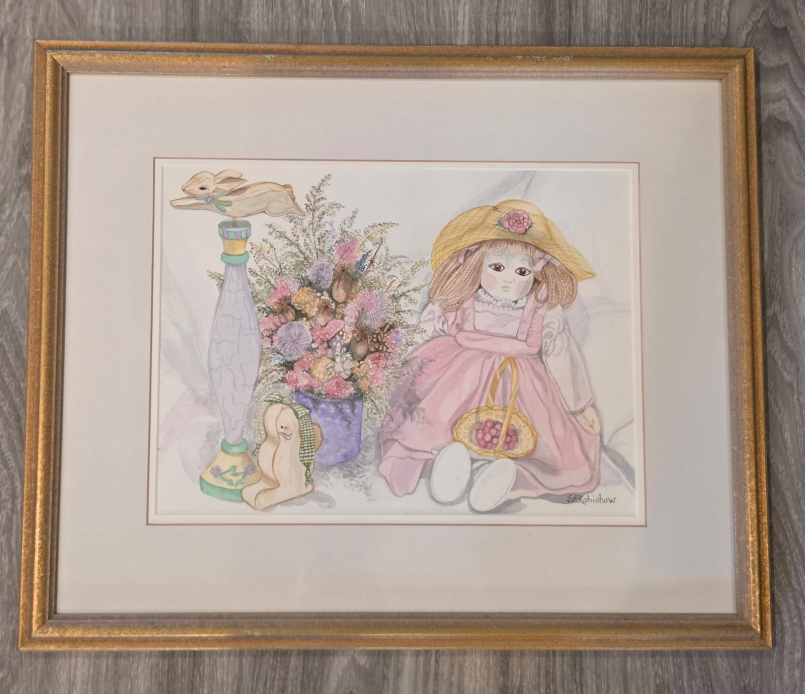 Doll & Flowers Still Life: Watercolor by Susan Robishaw, Massachusetts 1997. Gold frame, matted, 19" x 23". 100% of all proceeds from the sale of this lot will be donated to the Raise Your Banner Foundation, a Washington DC