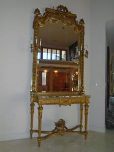 Grand entrance mirror & console with a marble top and: Grand entrance mirror & console with a marble top and gold frame. Has two 3 light sconce on either side. Small chip on bottom left. 112"H x 51"W x 19"D