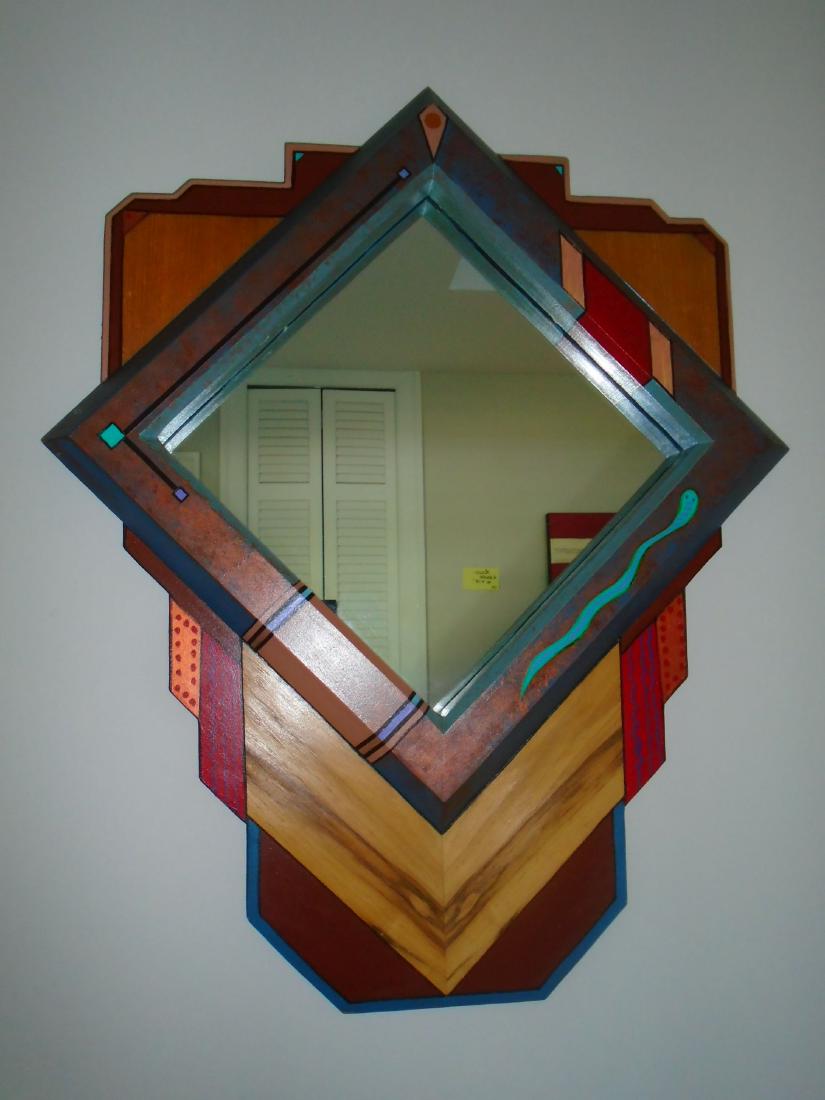 Wall hung mirror with wood frame.: Wall hung mirror with wood frame. multi colored design. 26 1/4"h x 21 1/4"w.