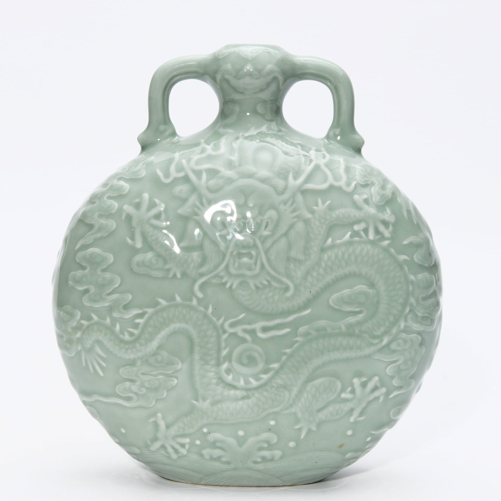 QIANLONG CELADON-GLAZED MOLDED DRAGON VASE: Dimensions: 8 1/4 x 7 1/4 in This Qianlong celadon-glazed molded dragon vase presents a refined fusion of sculptural relief decoration and elegant monochrome glaze aesthetics. The flattened circular