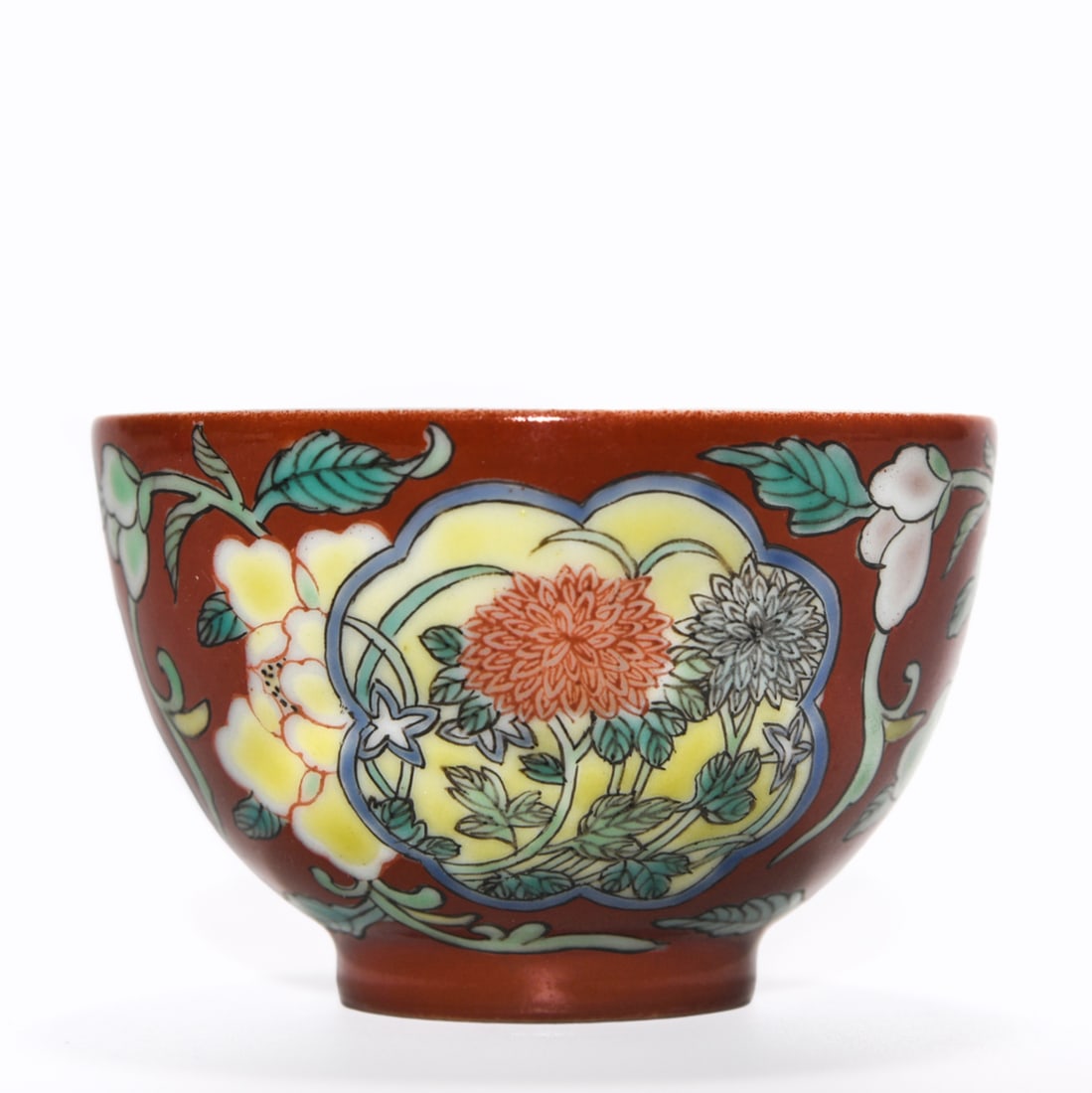 A YONGZHENG PERIOD FAMILLE ROSE FLORAL CUP: Dimensions: 1 5/8 x 2 1/2 in A Chinese porcelain cup decorated in famille rose enamels with floral motifs, the rounded body set on a short foot and finished with a warm-toned ground. Dimensions: 1
