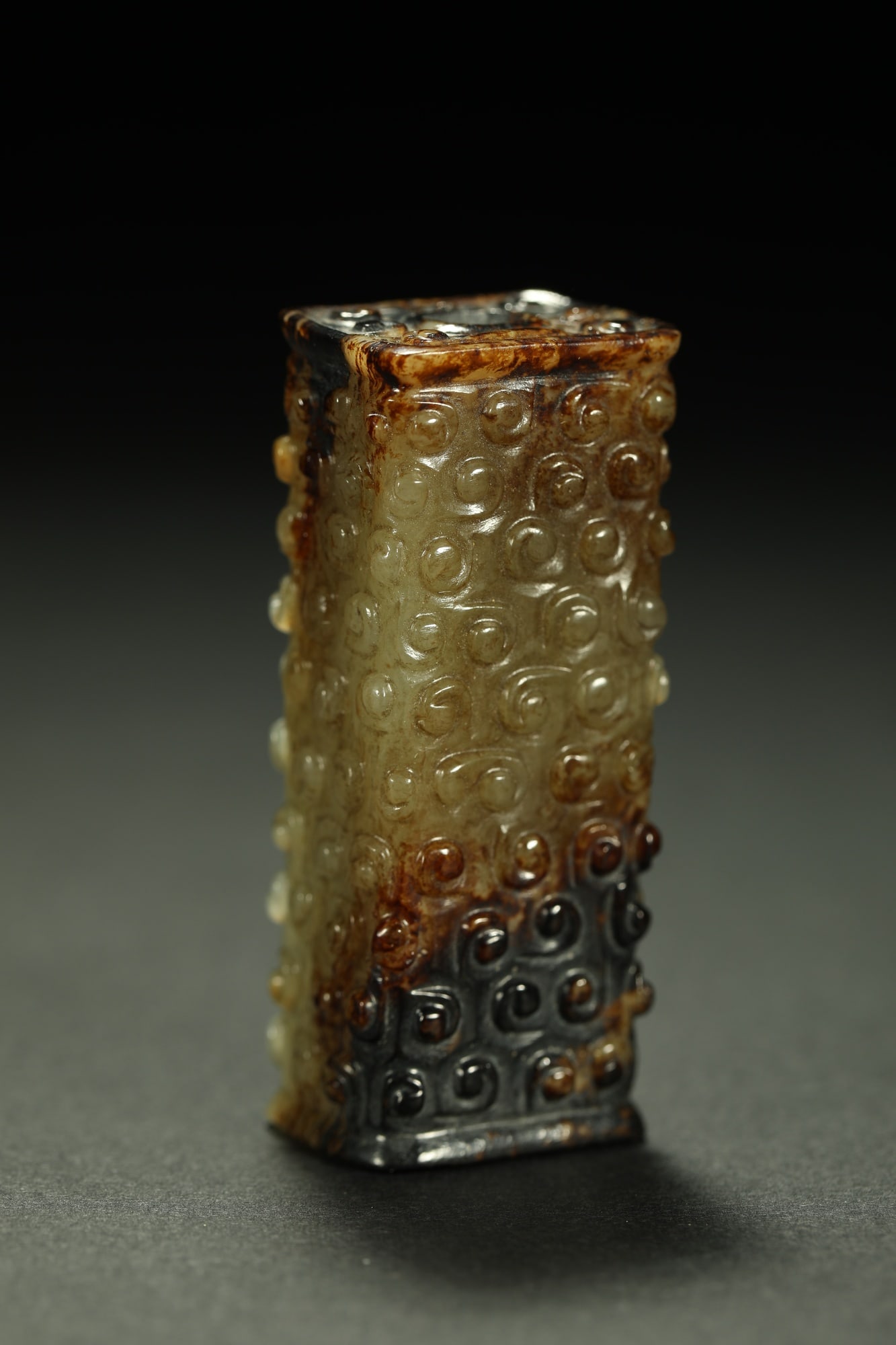 HETIAN JADE CYLINDRICAL ORNAMENT: Dimensions: 2 1/8 x 3/4 in; weight 52 g This Hetian jade cylindrical ornament presents a refined balance between natural jade texture and understated sculptural elegance. The elongated form is