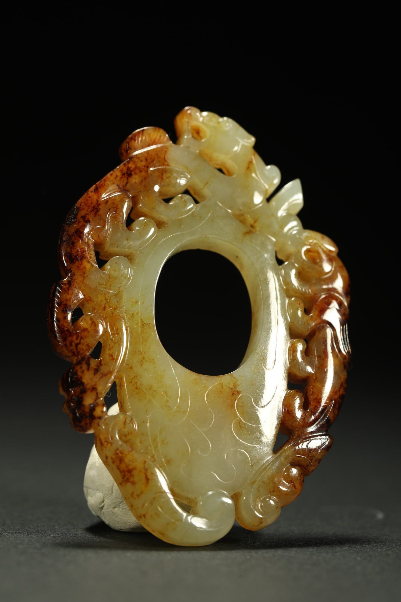 HETIAN JADE CHICKEN-HEART PENDANT: Dimensions: 2 1/2 x 1 3/4 in; weight 23.3 g This Hetian jade chicken-heart pendant presents a refined combination of natural jade beauty and elegant symbolic carving. The circular central aperture is 