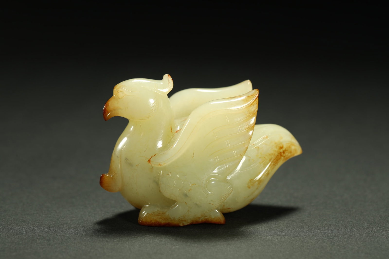 HETIAN JADE BIRD: Dimensions: 2 3/4 x 1 3/4 in; weight 108 g This Hetian jade bird carving presents a graceful interpretation of one of the most enduring subjects in Chinese decorative art. The compact figure is