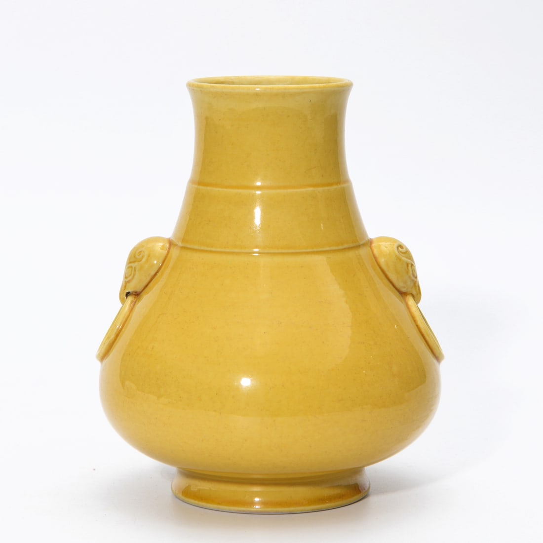 QIANLONG YELLOW-GLAZED VASE: Dimensions: 6 x 4 7/8 in This Qianlong yellow-glazed vase presents a refined monochrome elegance through its luminous glaze and graceful proportions. The rounded lower body and tall neck create a