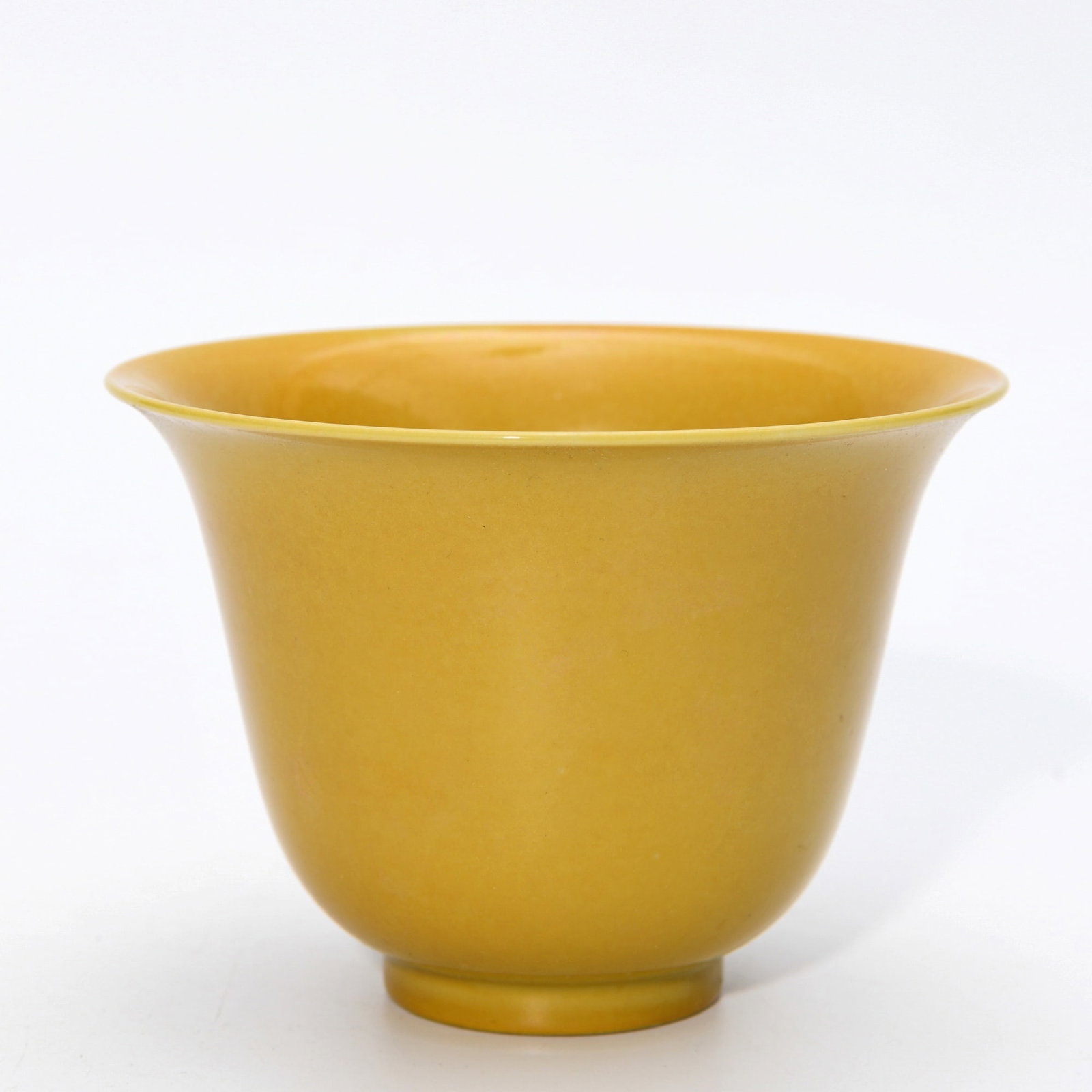 JIAJING YELLOW-GLAZED CUP: Dimensions: 3 1/2 x 4 7/8 in This Jiajing yellow-glazed cup presents a refined monochrome elegance through its luminous glaze and graceful proportions. The gently flaring body and delicate foot