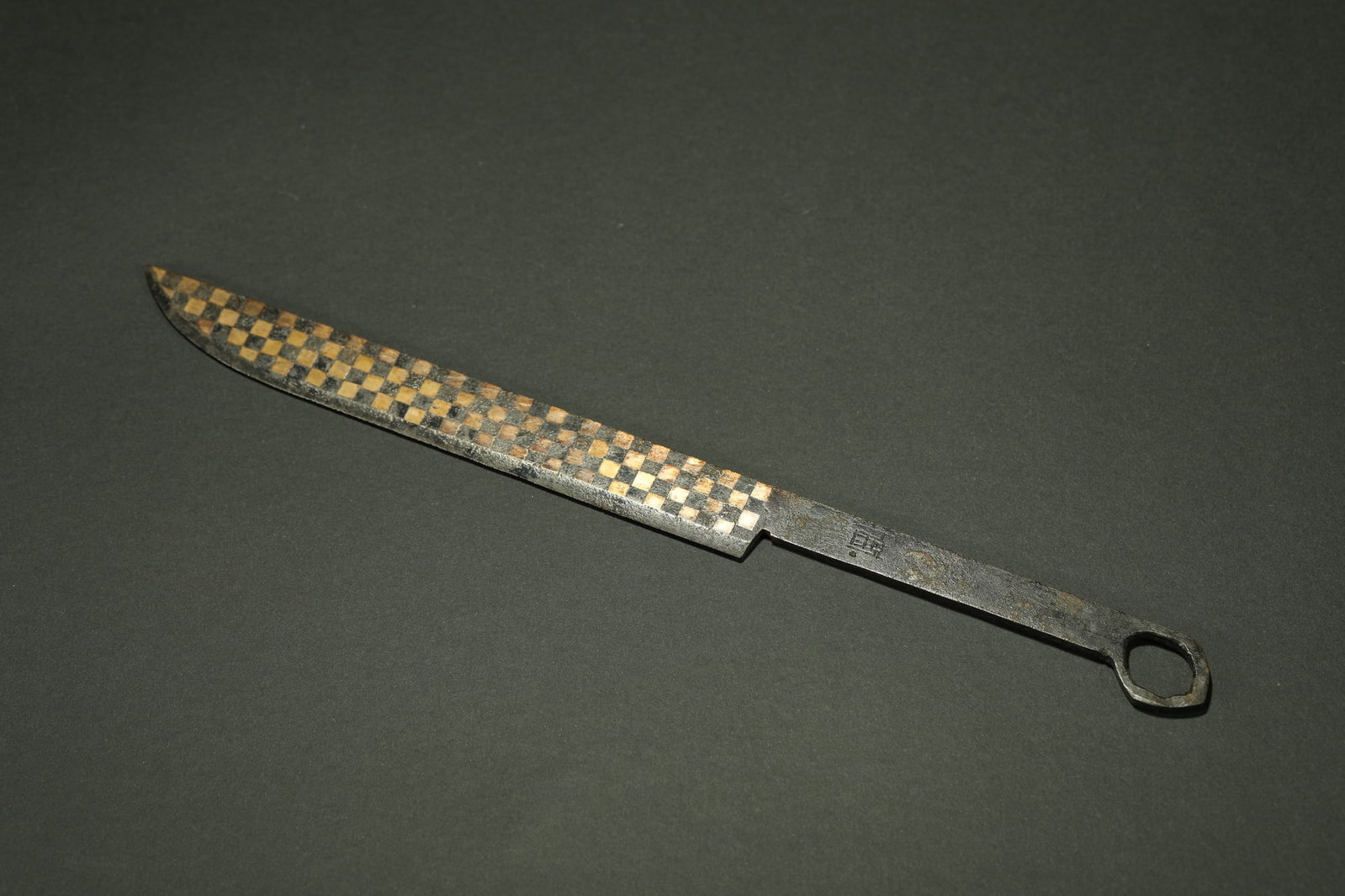 BRONZE GILT-SILVER KNIFE: Dimensions: 9 7/8 in; weight 73 g This bronze gilt-silver knife presents a striking ceremonial character through its elongated blade form and richly ornamented metal surface. The slender profile conve