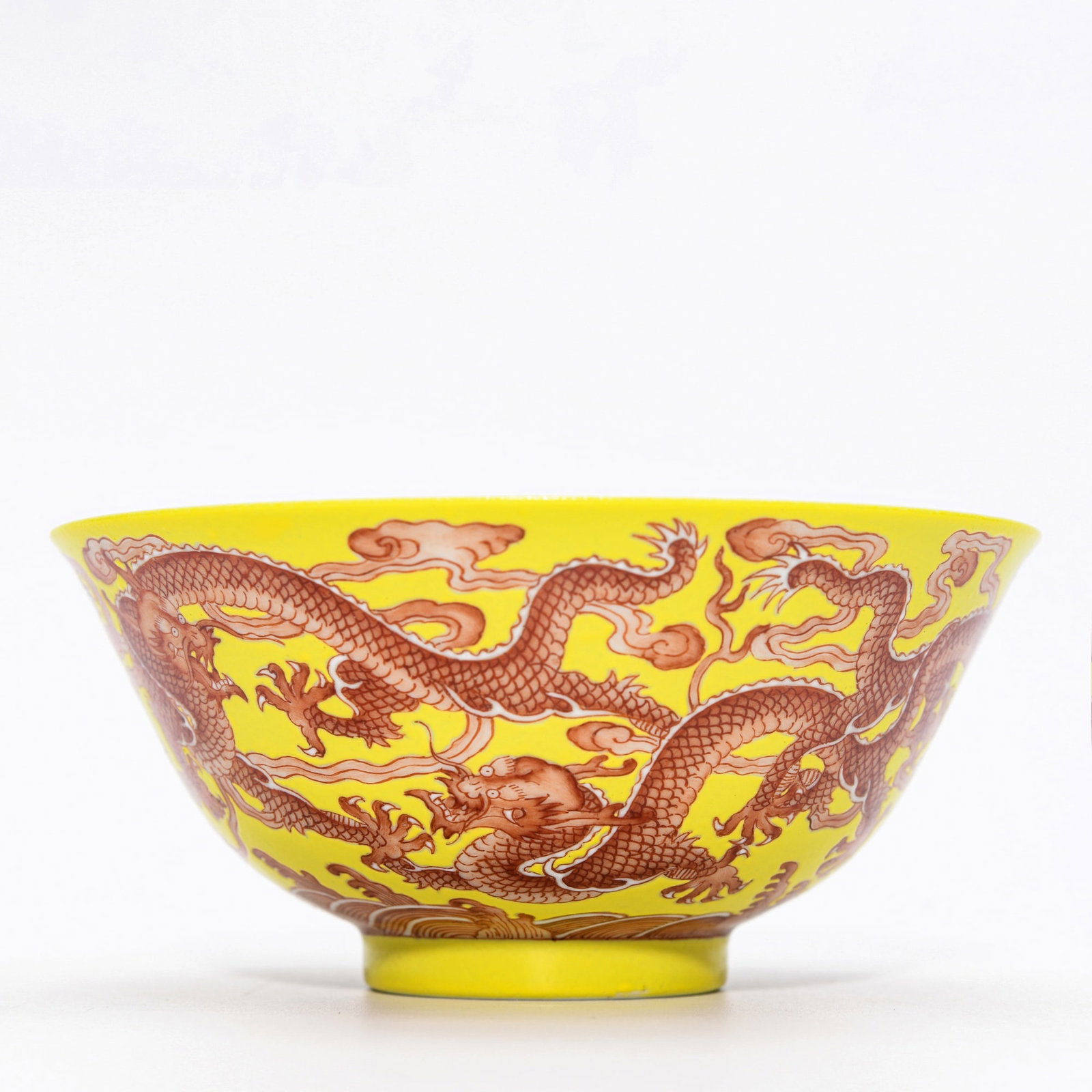 QIANLONG LEMON-YELLOW GROUND IRON-RED DRAGON BOWL: Dimensions: 2 1/4 x 4 8/7 in This Qianlong lemon-yellow ground iron-red dragon bowl displays a bold and highly decorative visual character through its vibrant palette and dynamic dragon imagery. The