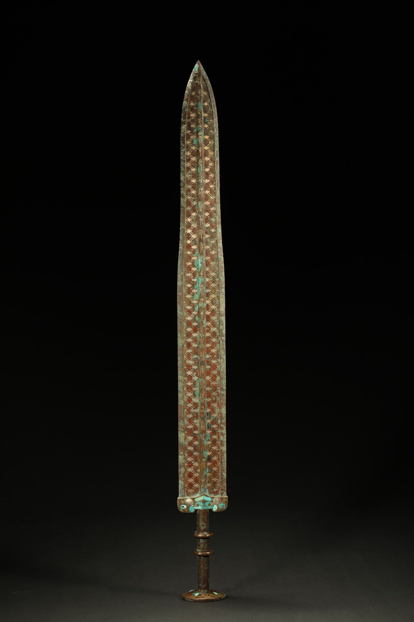 BRONZE GILT-SILVER SWORD: Dimensions: 23 5/8 in; weight 1091 g This bronze gilt-silver sword presents a commanding ceremonial elegance through its elongated blade and richly ornamented decorative surface. The straight blade fo
