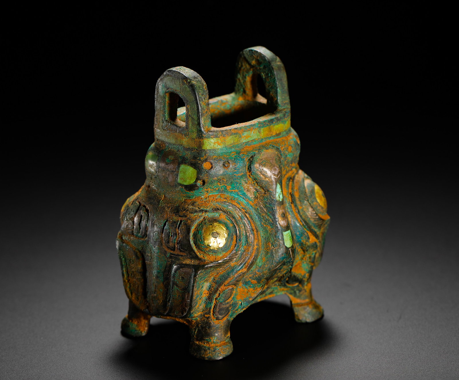 SHANG DYNASTY BRONZE INLAID GOLD AND SILVER INLAID TURQUOISE OWL-SHAPED TRIPOD: H:7.5cm (2.95in) W:5cm (1.97in) Weight:240g (0.53lb) This ding is a late Shang Dynasty bronze vessel shaped like an owl. The surface is decorated with intricate patterns inlaid with gold, silver, and 