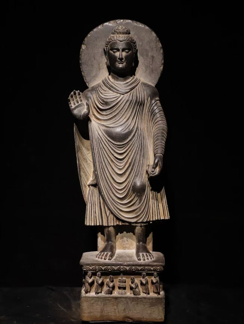 3RD CENTURY KANDA STONE BUDDHA: H:120cm(47.24in) W:40cm(15.75in) T:22cm(8.66in) Standing Shakyamuni Buddha carved from schist, Gandhara art of the 2nd?C3rd century Kushan Dynasty, a Hellenistic Buddhist stone sculpture. The Buddha f