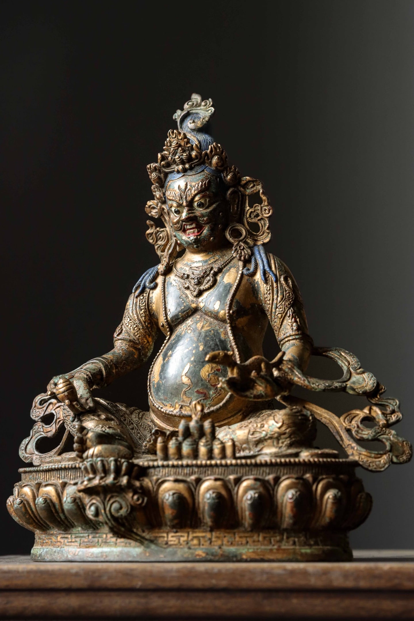 GILDED BRONZE STATUE OF THE YELLOW GOD OF WEALTH FROM THE QING DYNASTY: Weight:3000g (6.61lb) H:27.5cm (10.83in) W:24cm (9.45in) T:13.5cm (5.31in)Cast bronze with partial gilding and blue pigment on hair: seated on double lotus base, the foremost of five major Tibetan wea