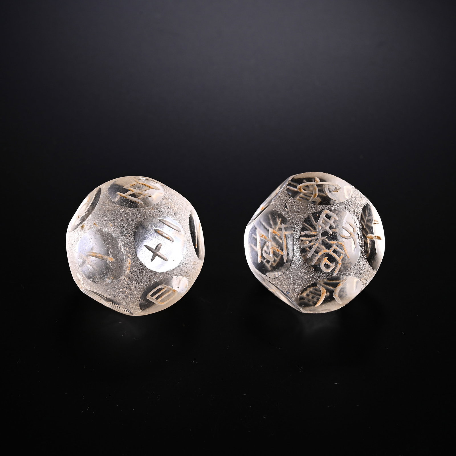 A PAIR OF NATURAL CRYSTAL TWELVE-FACED BORONS FROM THE HAN AND WEI DYNASTIES: D:3cmWeight:90gPair of natural crystal twelve-sided Boqiong, Han-Wei Dynasty. Transparent clear crystal with thousand-year weathered pits and yellow earth patina all over the surface. Each facet