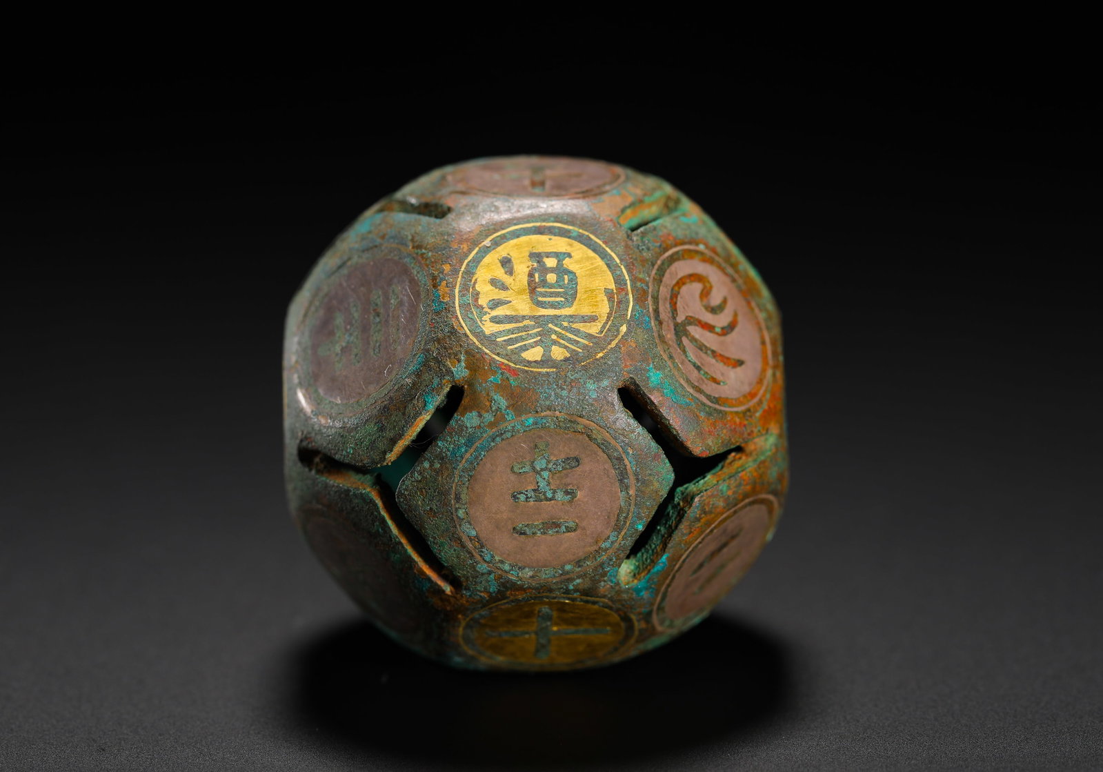 BRONZE DODECAHEDRAL HOLLOWED-OUT WINE DICE (BOQIONG): D:4.2cmWeight:85gDodecahedron hollow bronze die for ancient drinking games, decorated with fine gold inlay. Each facet bears inscribed characters such as "wine", numerals and symbolic patterns, with h