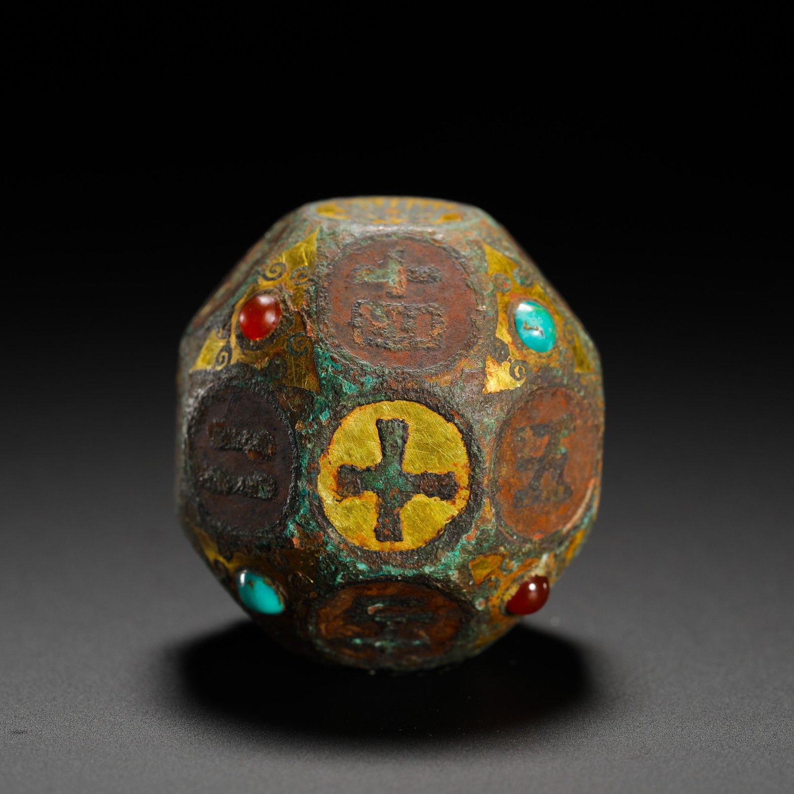 GOLD INLAID BRONZE DIVINATION DICE FROM THE WARRING STATES PERIOD: D:3.3cm(1.30in) Weight:200g(0.44lb)Warring States fourteen-sided bronze divination dice inlaid with gold, turquoise and agate. The bronze body is outlined with gold cloud scroll borders, each circular