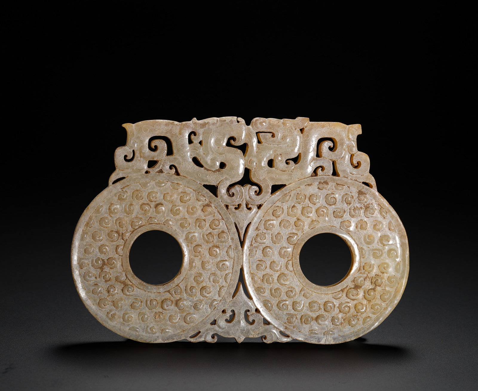 HAN DYNASTY JADE DOUBLE-DISC DRAGON-PATTERNED PENDANT: H:7.7cm(3.03in)W:11.5cm(4.53in)Weight:100g(0.22lb)These objects were worn by Han Dynasty nobles. The grain pattern symbolized abundant harvests, and the dragon pattern symbolized authority and good