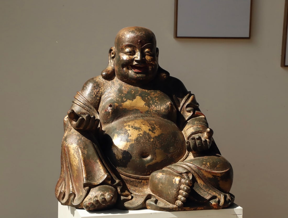 A GILDED BRONZE MAITREYA STATUE FROM THE MING DYNASTY: Weight:23000g(50.71lb) H:46cm(18.11in) L:48cm(18.90in) W:42cm(16.54in) This is a gilded bronze seated statue of Maitreya Buddha (Budai Monk) from the Ming Dynasty. Cast from fine bronze with overall g