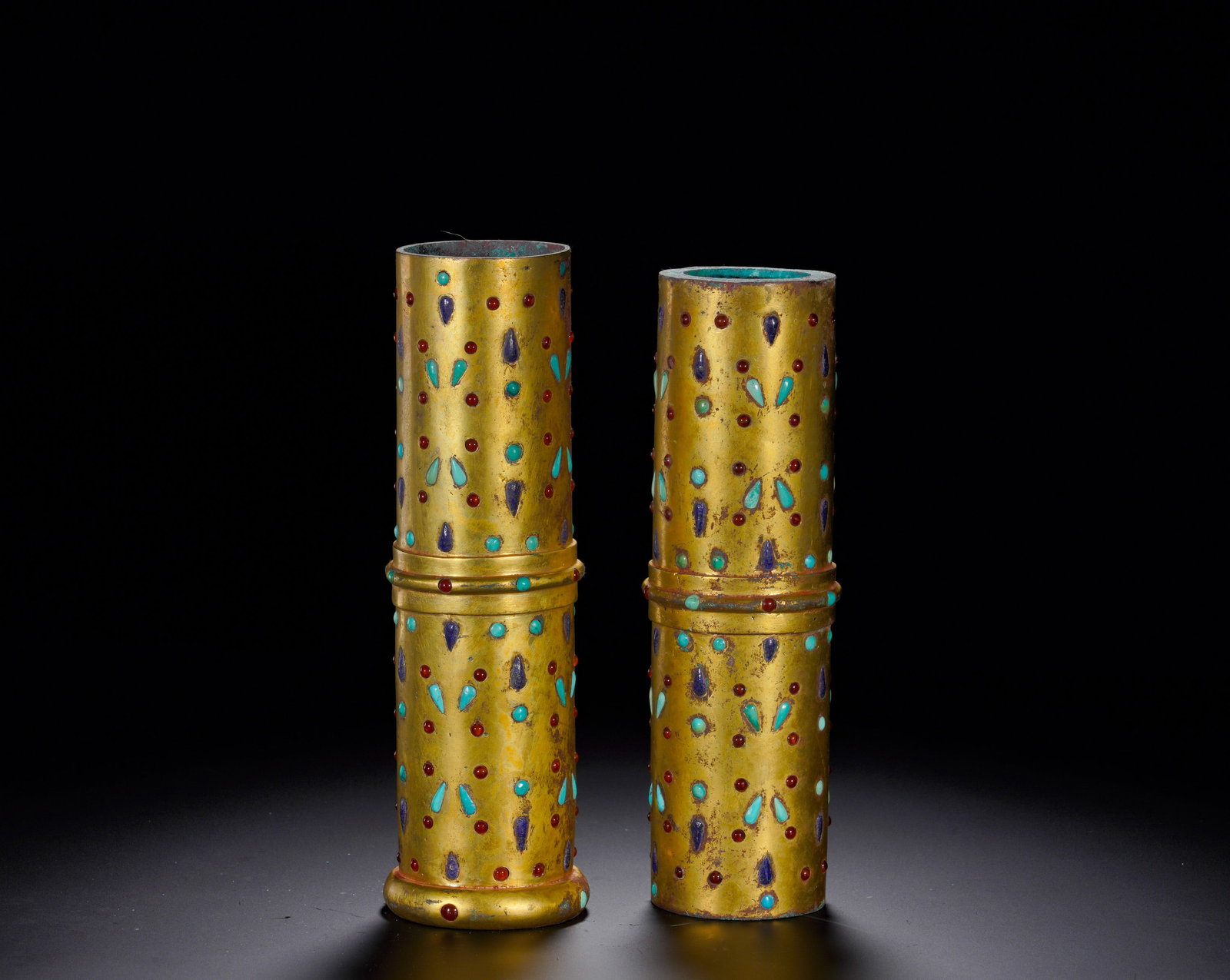 BRONZE GILDED AND GEM-INLAID CYLINDRICAL VESSEL OF THE HAN DYNASTY: Height:9.5cm(3.74in) Width:5cm(1.97in) Weight:1670g(3.68lb)Straight gilt bronze vessels divided into upper and lower sections, outer wall inlaid with drop-shaped agate, turquoise and lapis lazuli. The