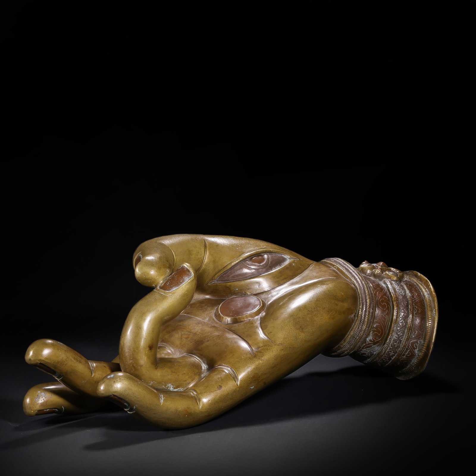 BRONZE INLAID SILVER BUDDHA HAND PRINTS OF THE QING DYNASTY: H:16.0cm(6.30in) W:42.0cm(16.54in) Weight:6950g(15.32lb)This is a bronze Buddha hand mudra ornament, with a Buddha eye (wisdom eye) carved on the palm, inlaid with red copper/silver decorations. The