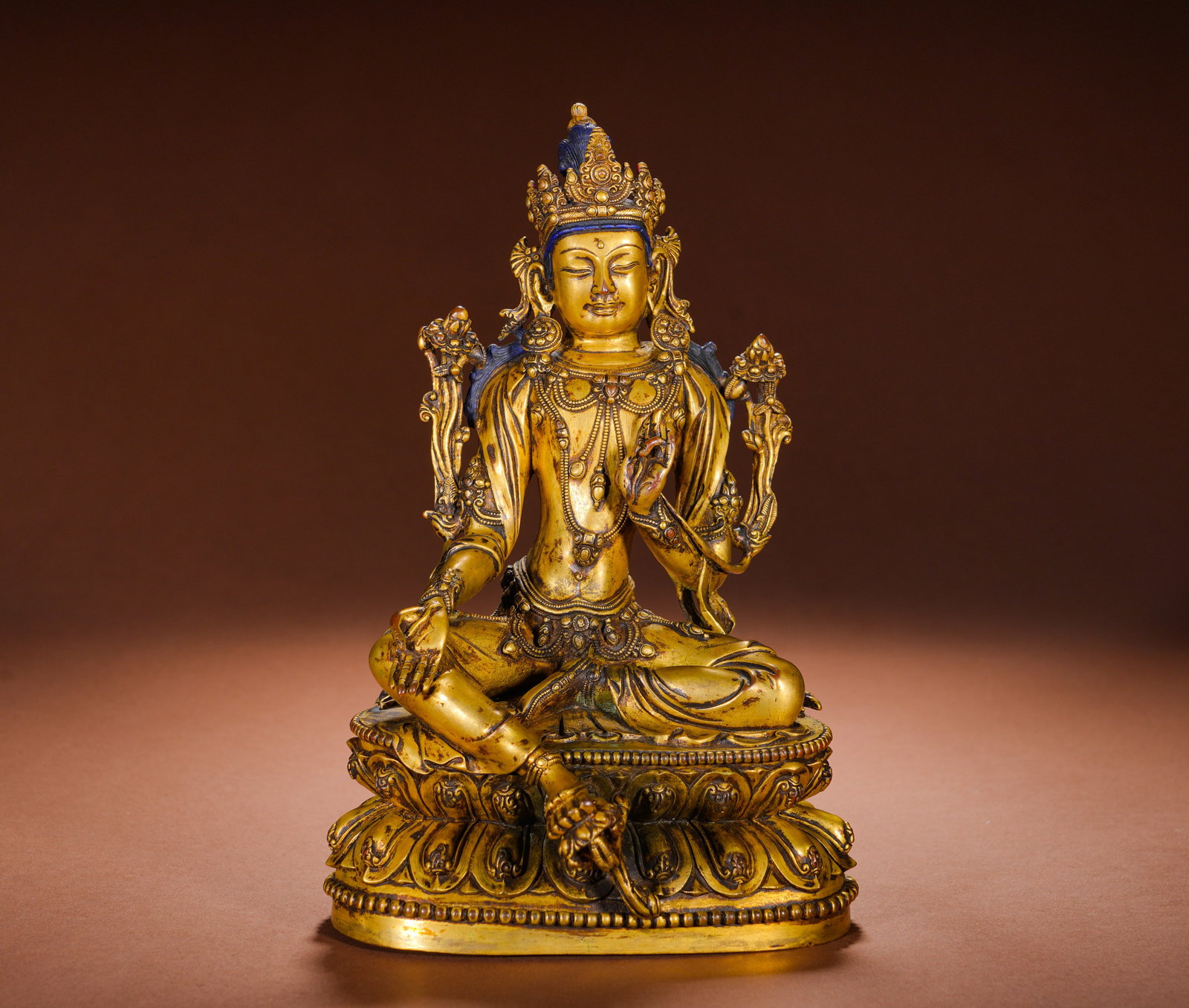 A GILDED BRONZE STATUE OF TARA FROM THE QING DYNASTY: Height:24cm(9.45in), Width:16cm(6.30in), Weight:2530g (5.578lb)Cast in copper with full gilding, crowned with an ornate diadem and draped in elaborate pearl ornaments. Seated in relaxed half-lotus pos